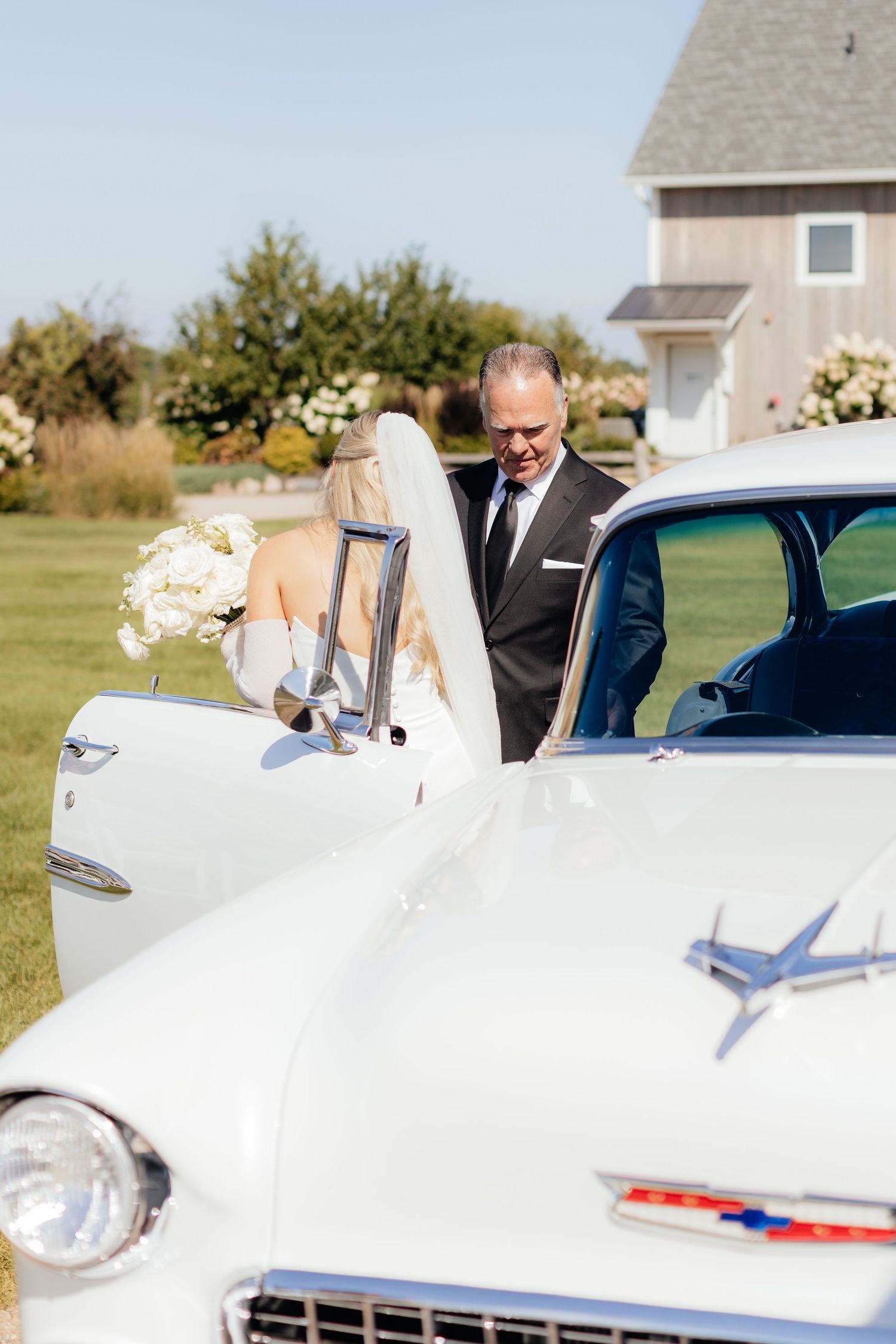 Classic white Chevrolet serves as elegant wedding day transportation.