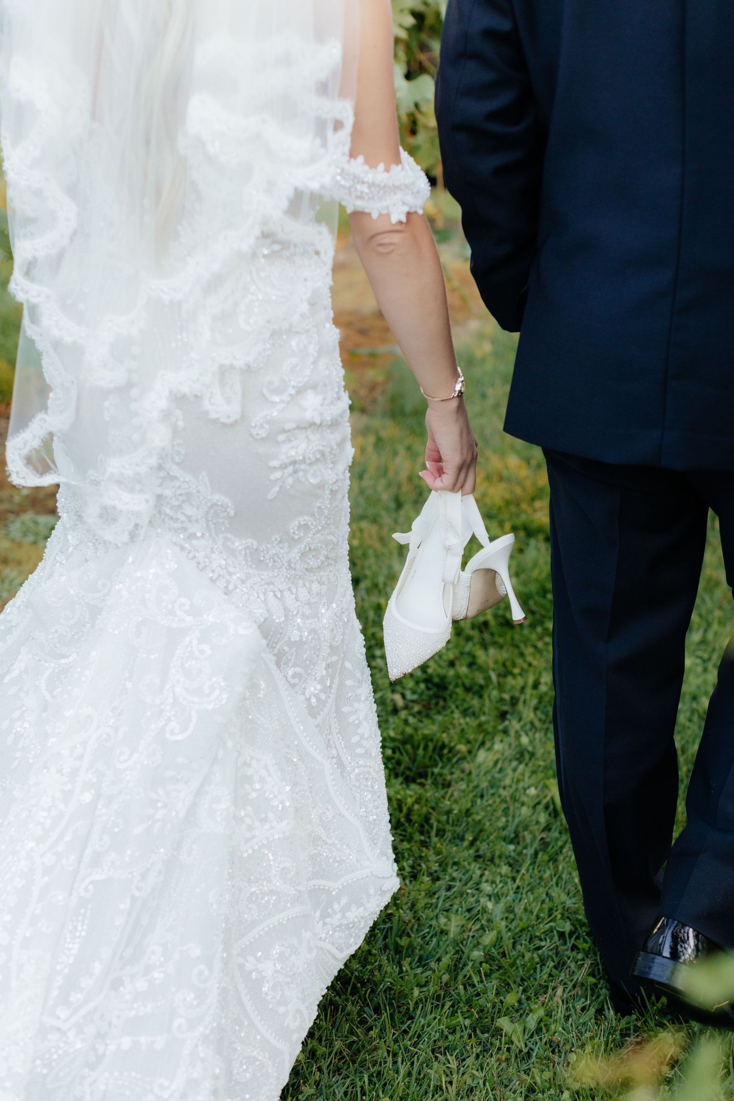 Detail shots of intricate lace wedding dress and formal attire during outdoor ceremony.