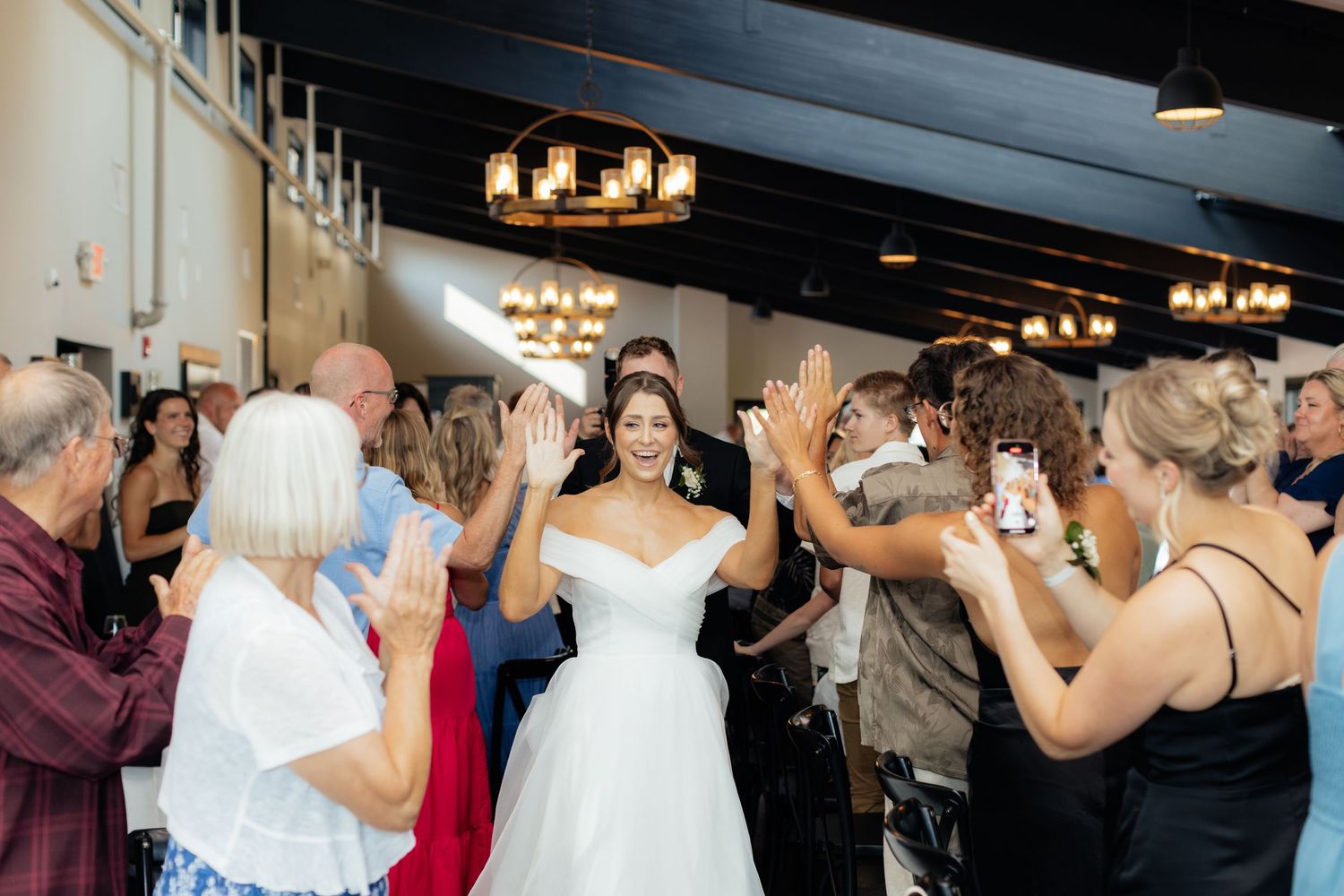 Wedding reception dance floor with guests celebrating under dim lighting.