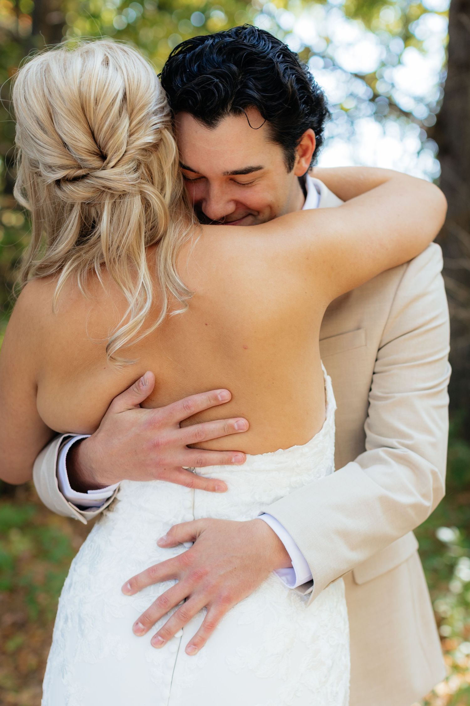 Intimate embrace between newlyweds during outdoor wedding photoshoot.