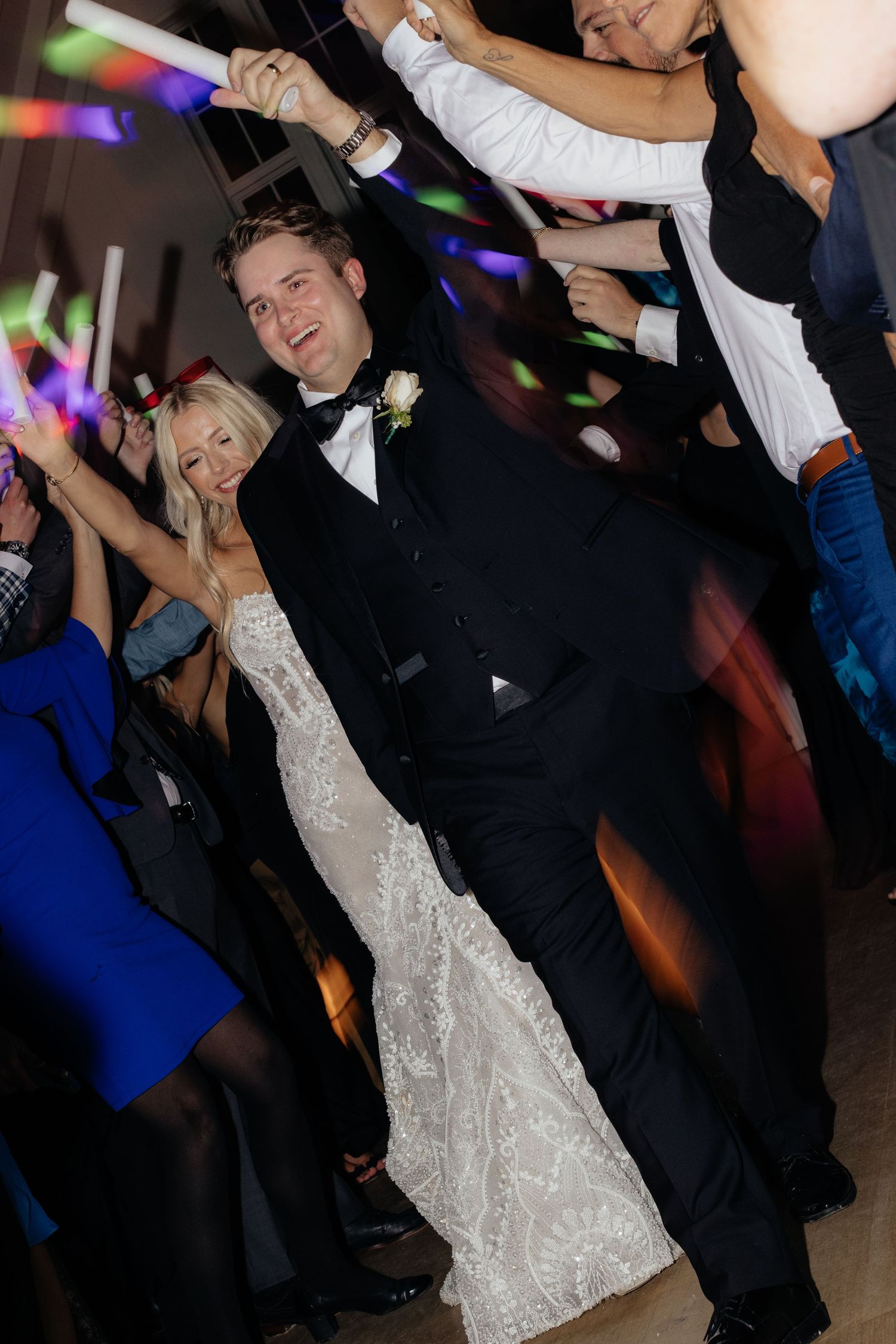 Wedding reception dance floor scene with colorful party lights and celebration.
