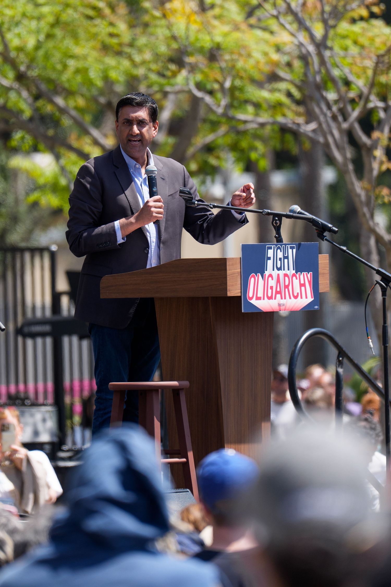 Political speaker addressing crowd from podium at outdoor campaign rally.