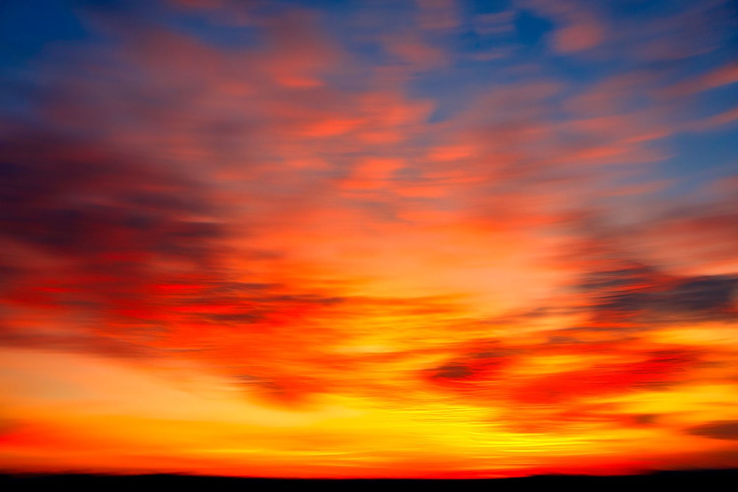 Vibrant sunset sky with fiery red, orange, and yellow clouds dramatic twilight landscape photography.