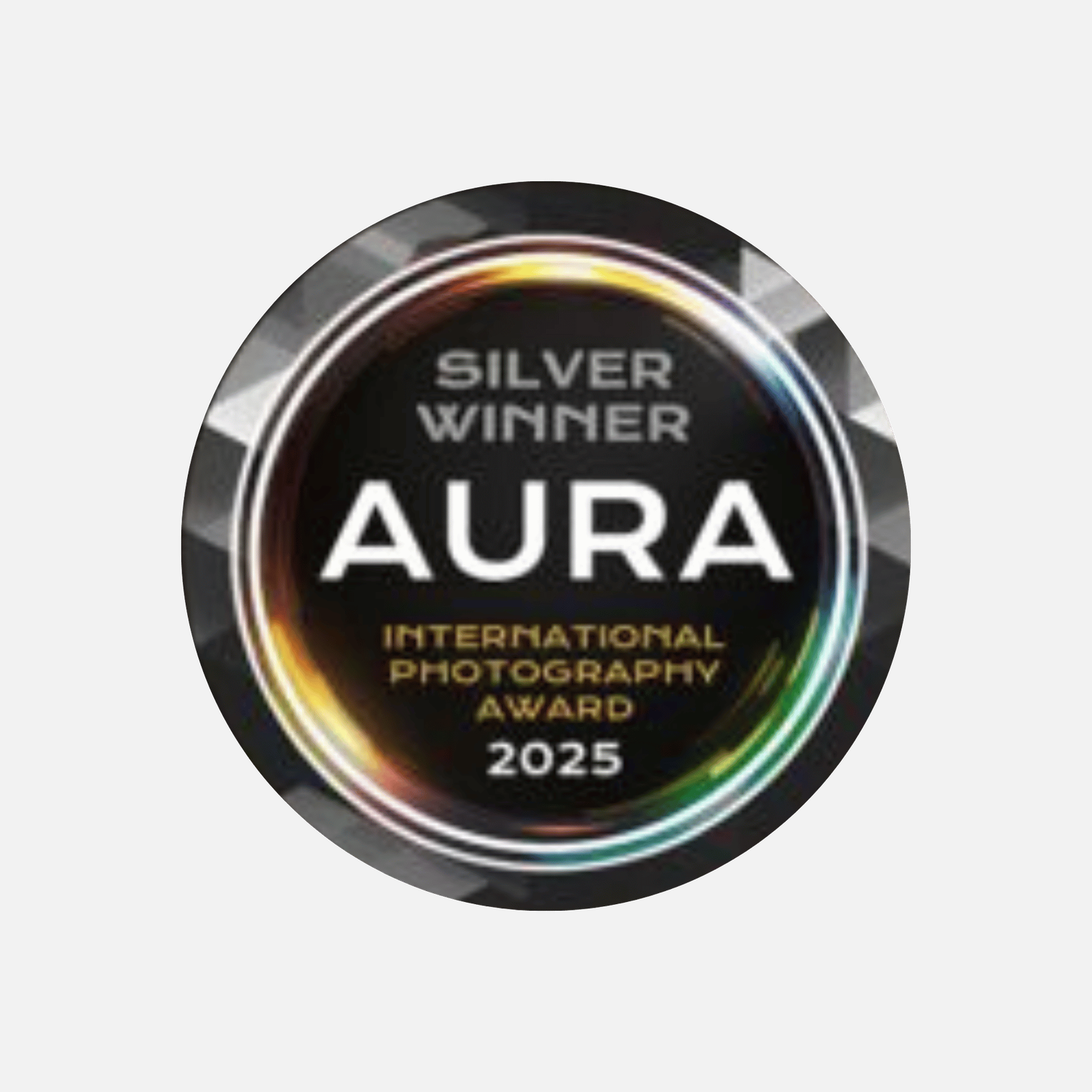 Silver Winner badge for the AURA International Photography Award 2025, featuring a metallic circular design with rainbow accents.