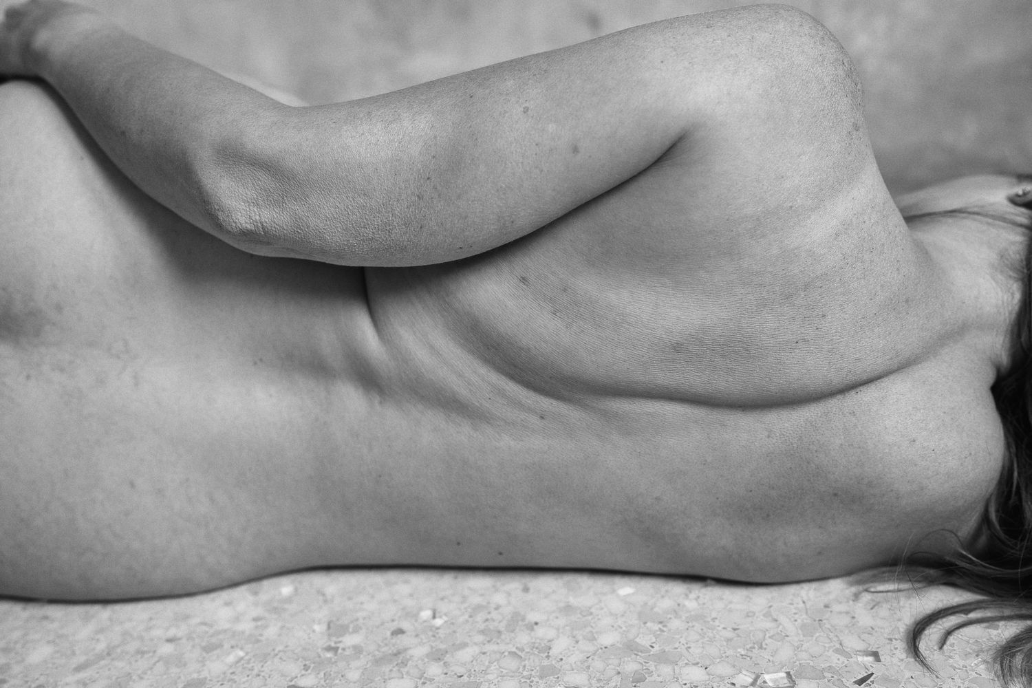 Black and white artistic photograph of a human back, showcasing natural body curves and form.