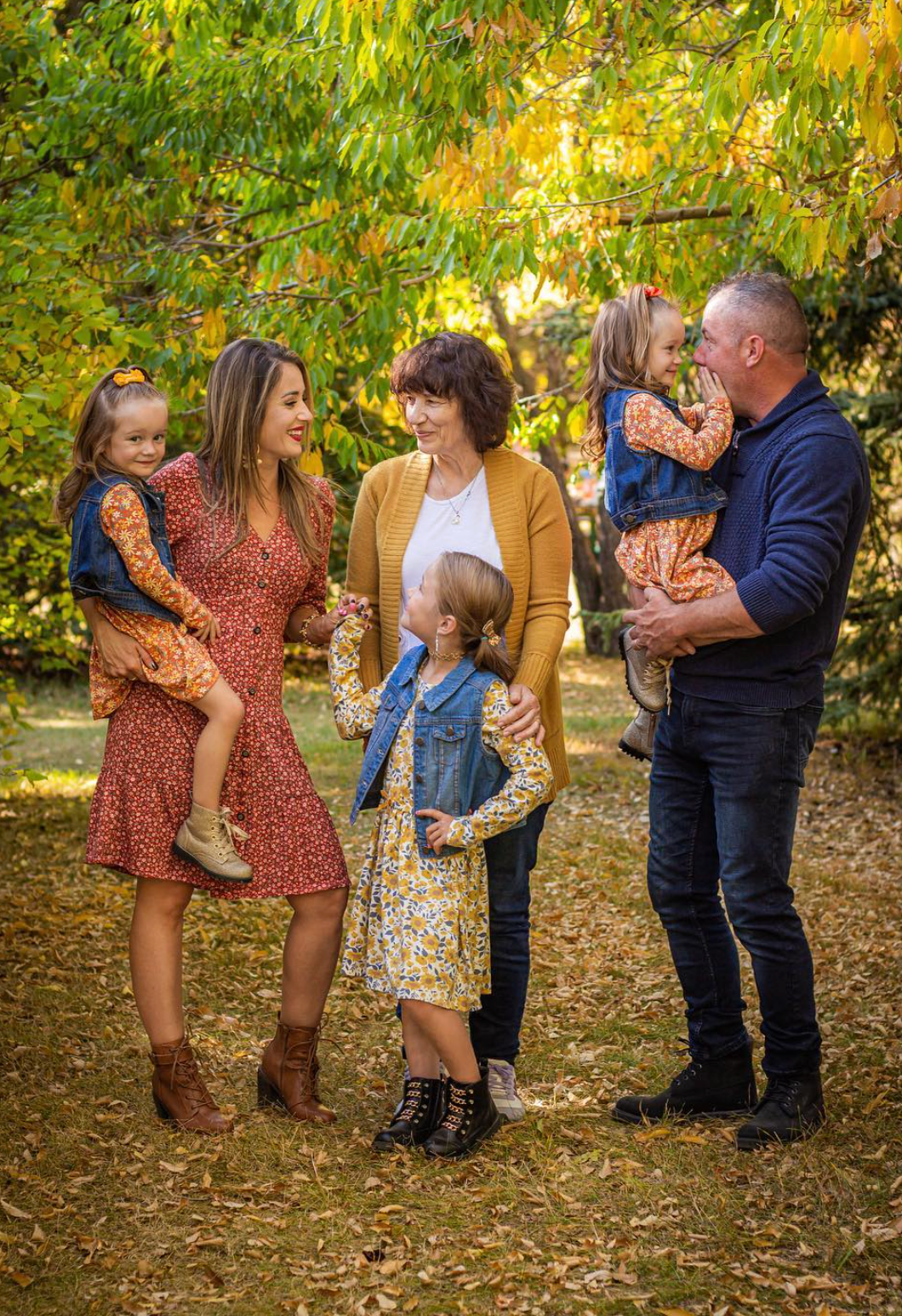 Family looking at each other under orange and yellow autumn trees