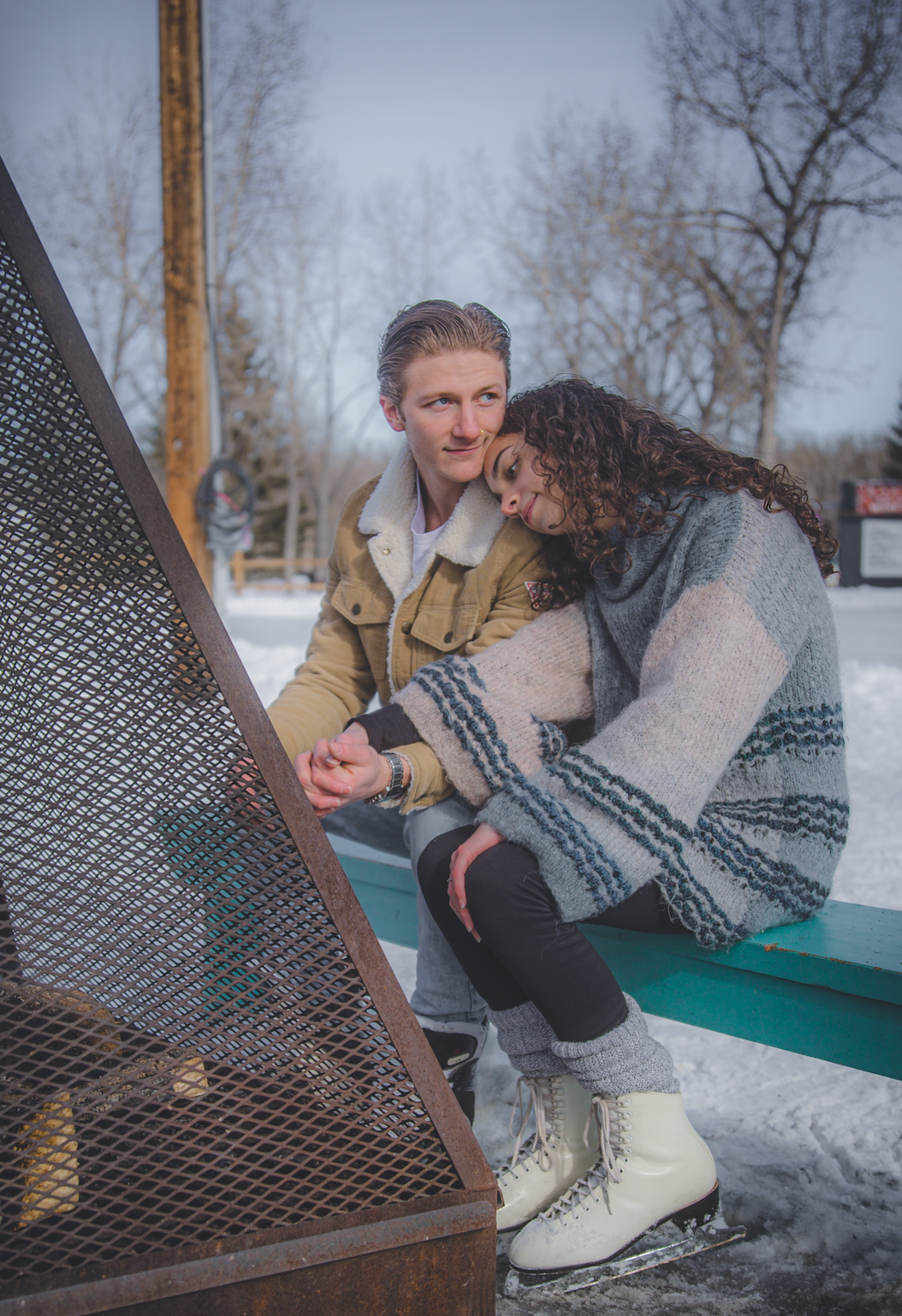 women leaning her head on mans shoulder by a outdoor fire