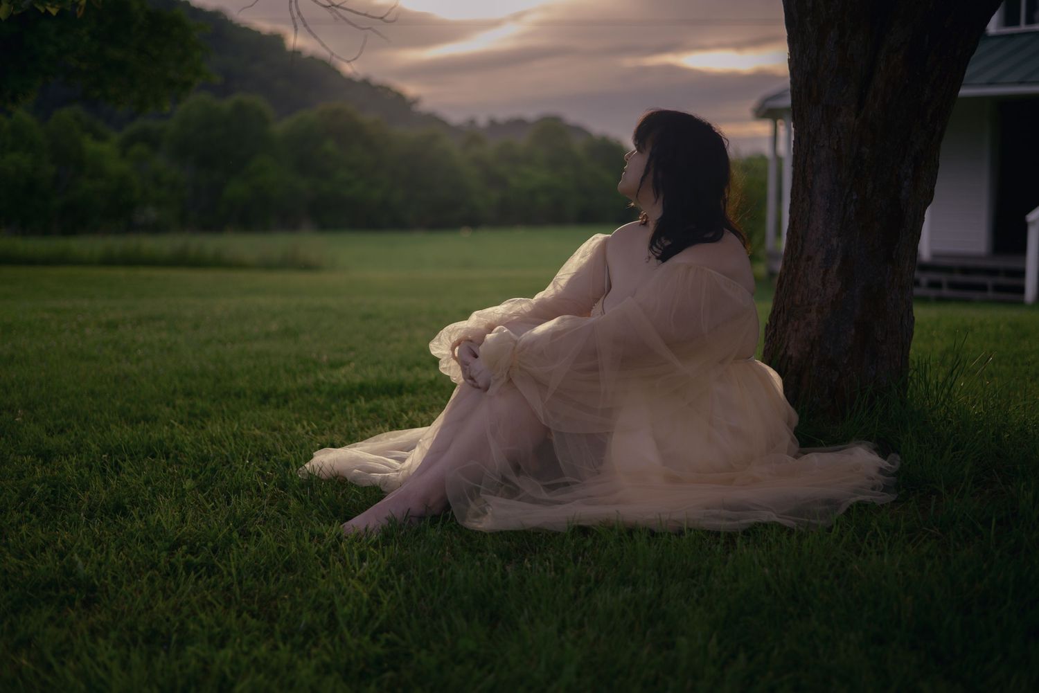 Ethereal sunset portrait session in flowing dress against natural landscape.
