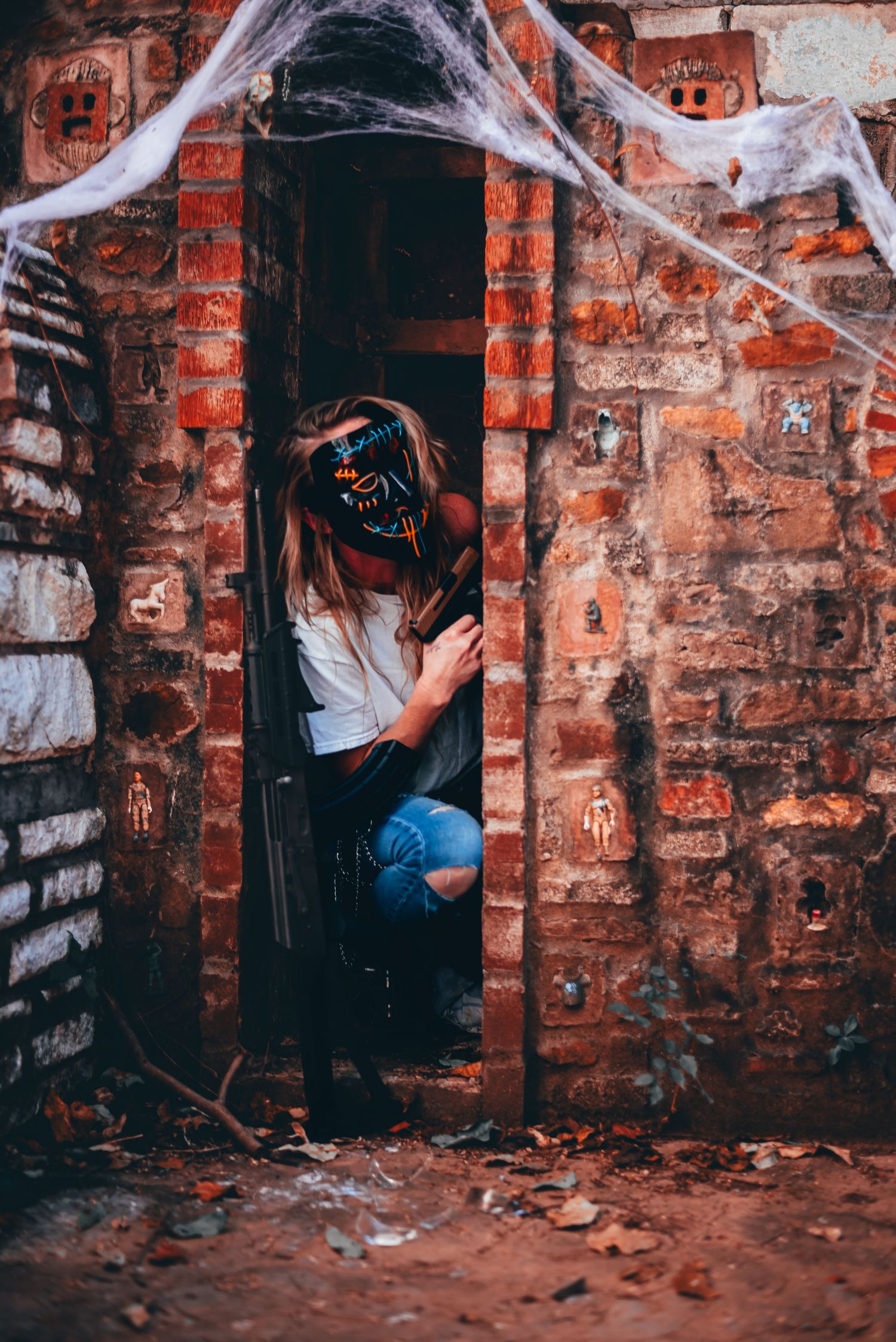 Urban exploration series with figure in abandoned brick building covered in cobwebs.