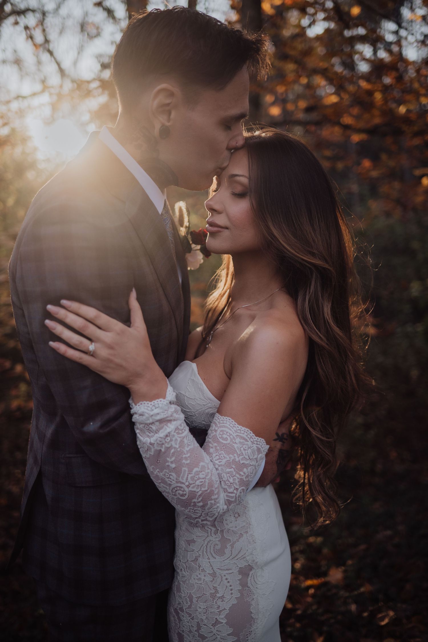 Intimate wedding portraits captured during golden hour in a fall forest setting.