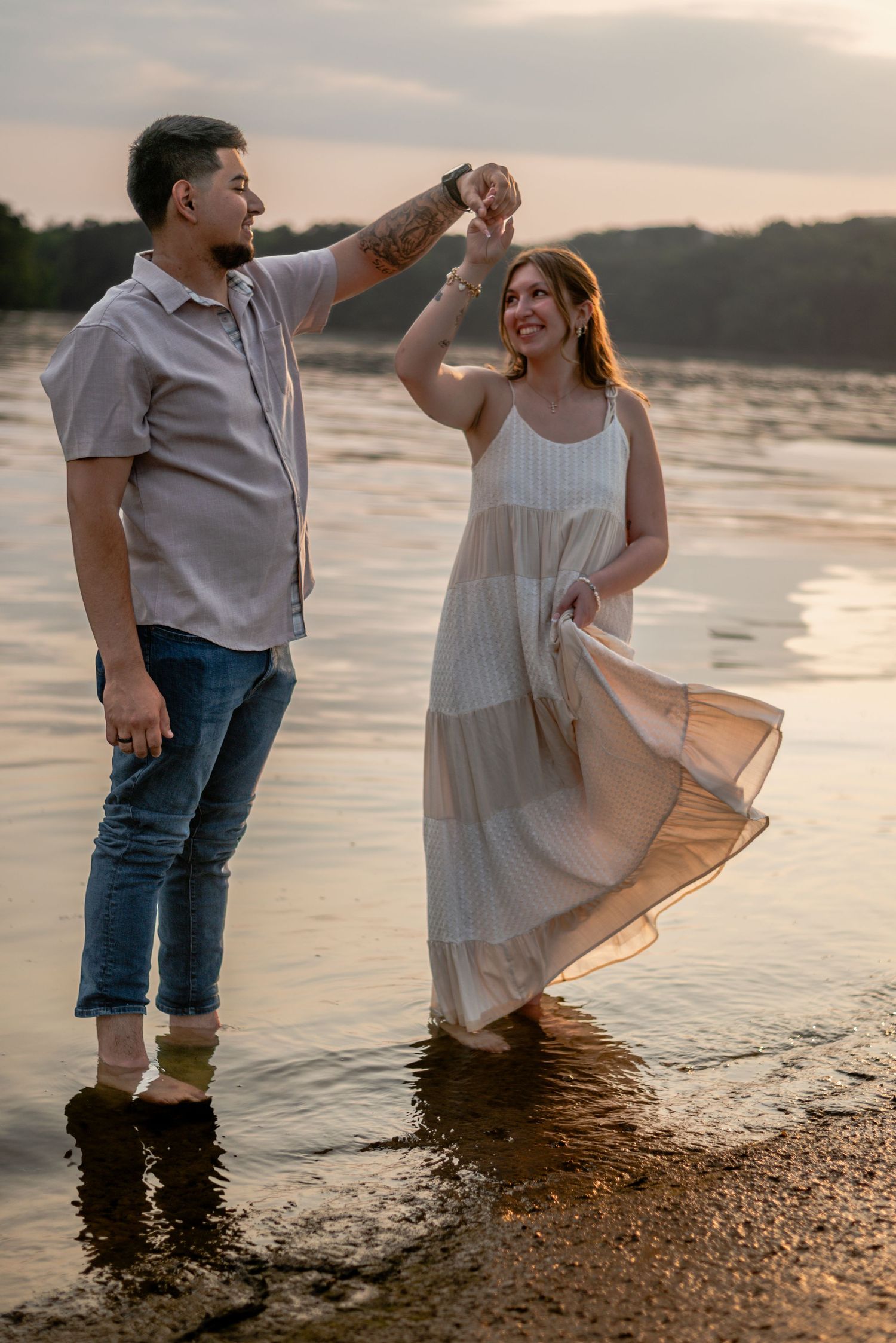 A couple dancing and twirling on a beach at sunset, creating a joyful and romantic atmosphere.