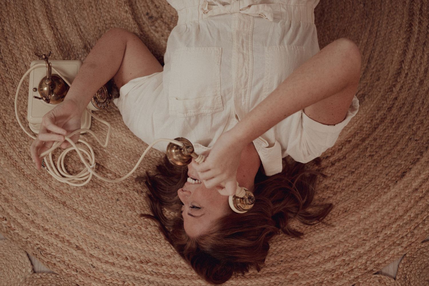 Dreamy overhead portrait on a circular rug with vintage styling and soft lighting.