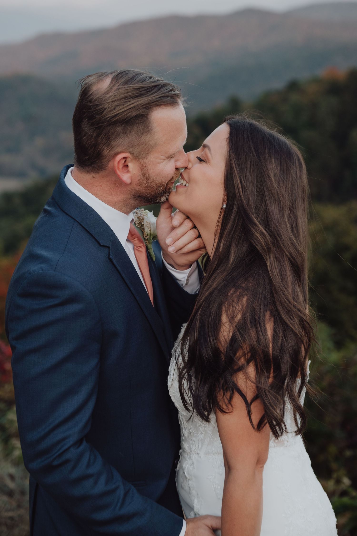 An intimate wedding portrait captured against a backdrop of autumn mountains.