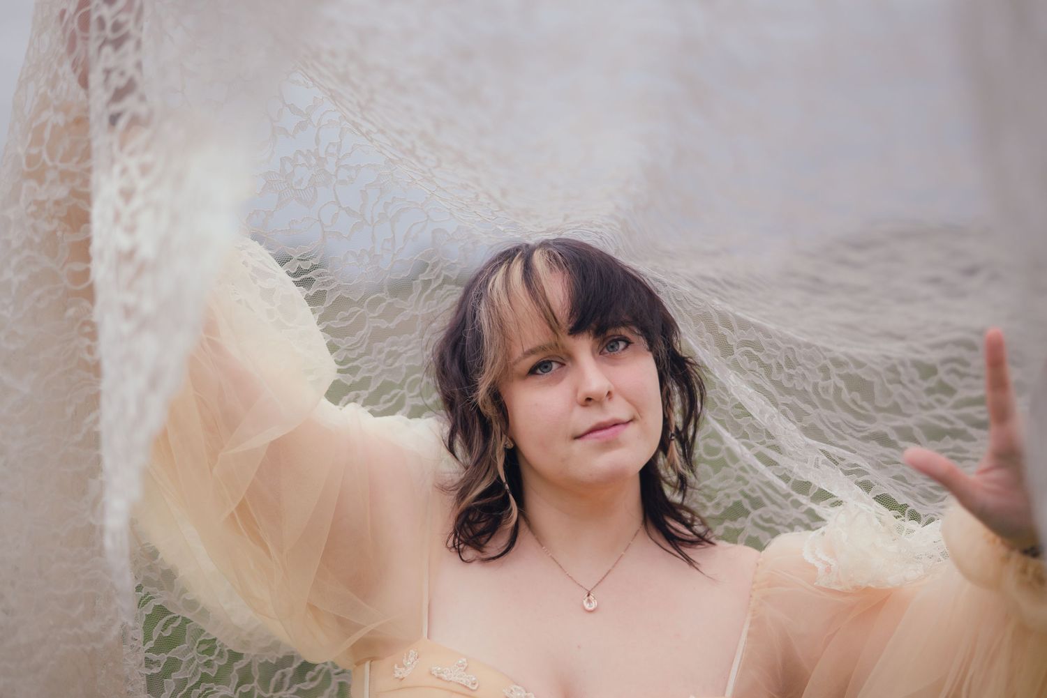 Ethereal bridal portraits in a field with flowing cream colored dress.
