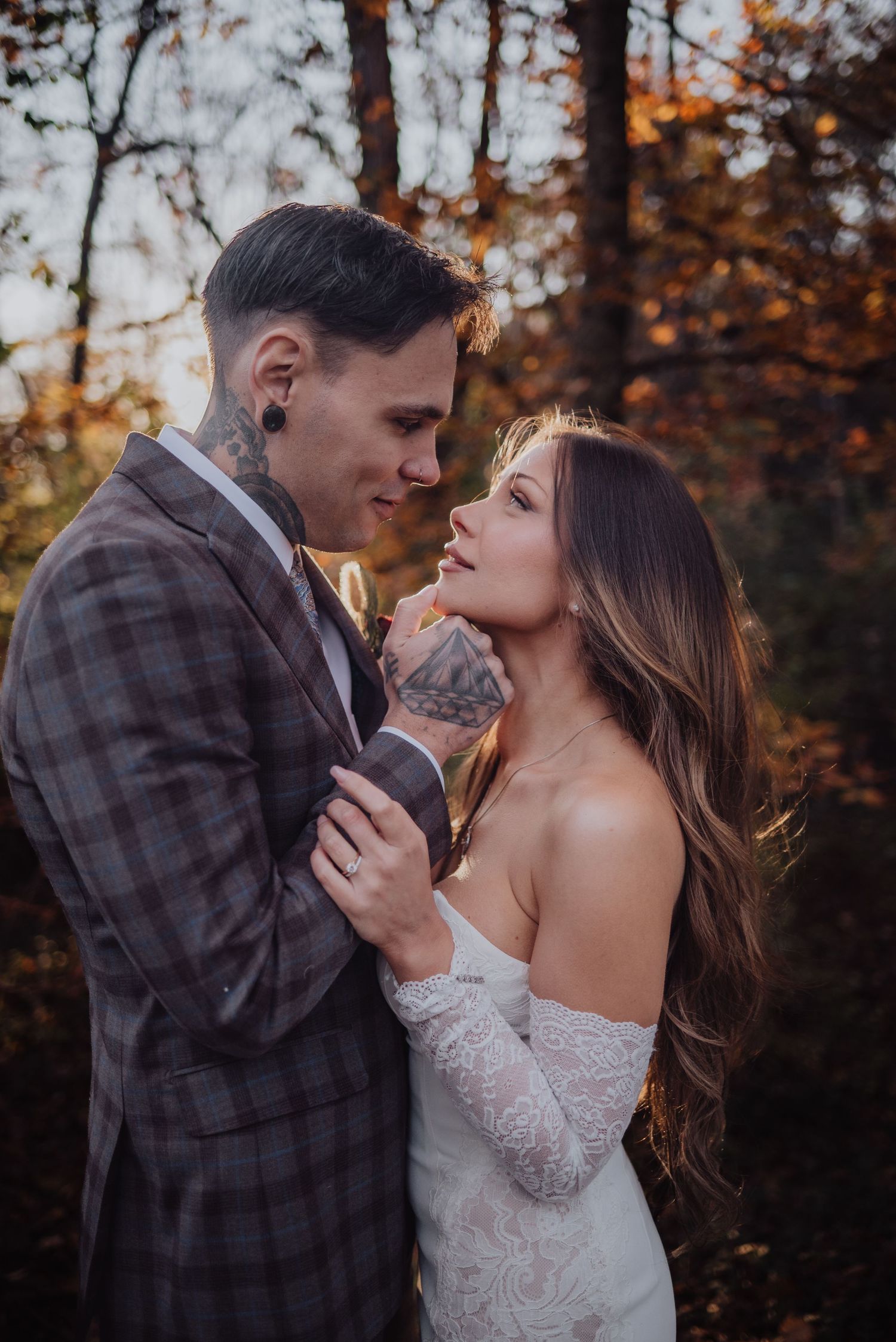 Romantic autumn wedding photoshoot with couple embracing in golden sunlight.