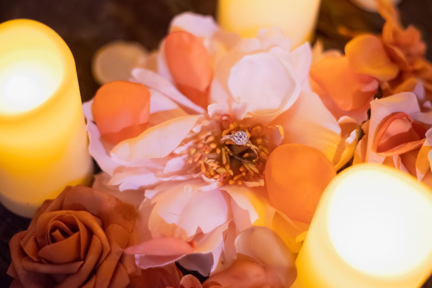 Soft-lit floral arrangement with roses and candles creating a romantic ambiance.
