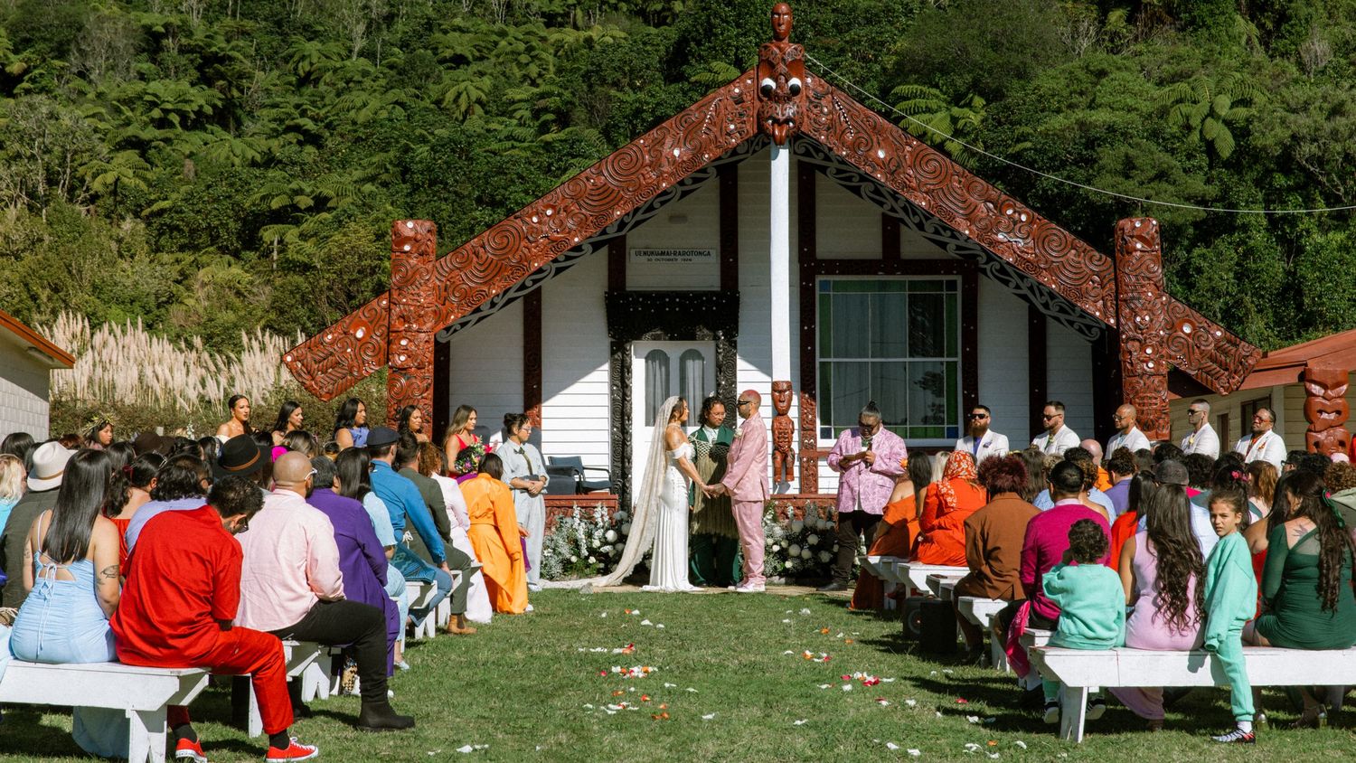 Traditional Maori cultural performance and gathering at a marae with carved meeting house in New Zealand.