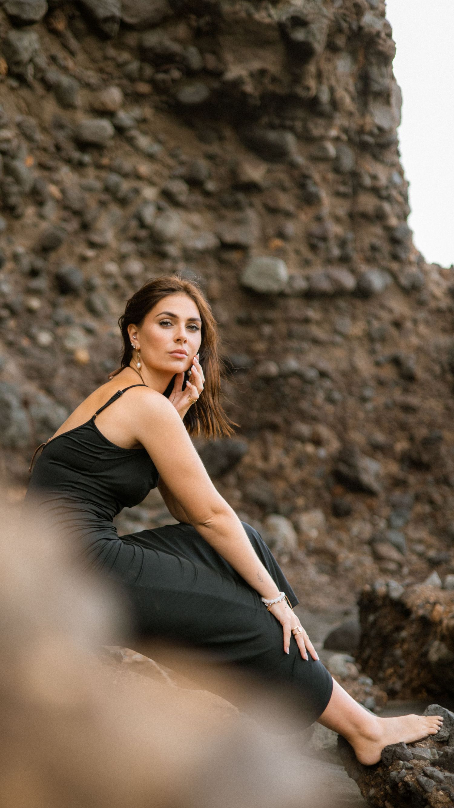 Graceful pose on rocky terrain during outdoor photo session.