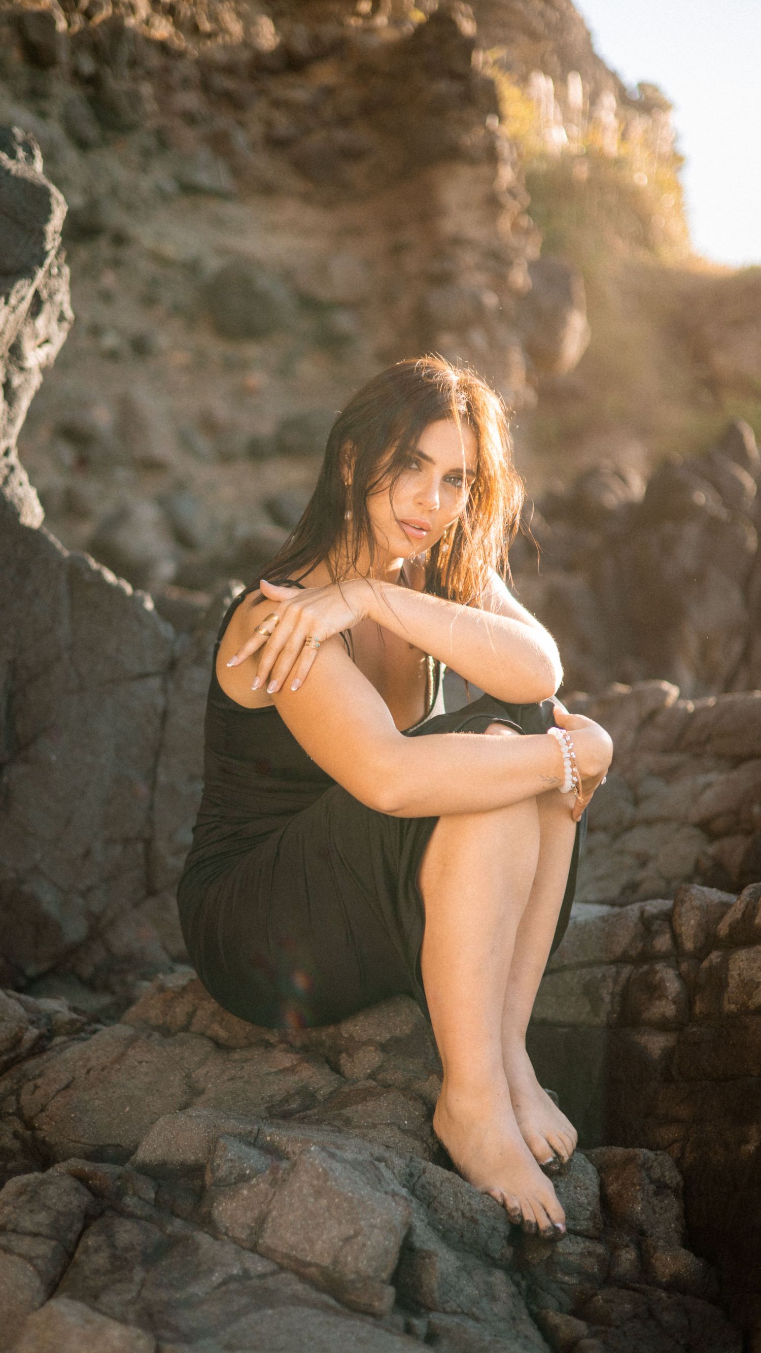 Natural light portrait on rocky beach during golden hour.