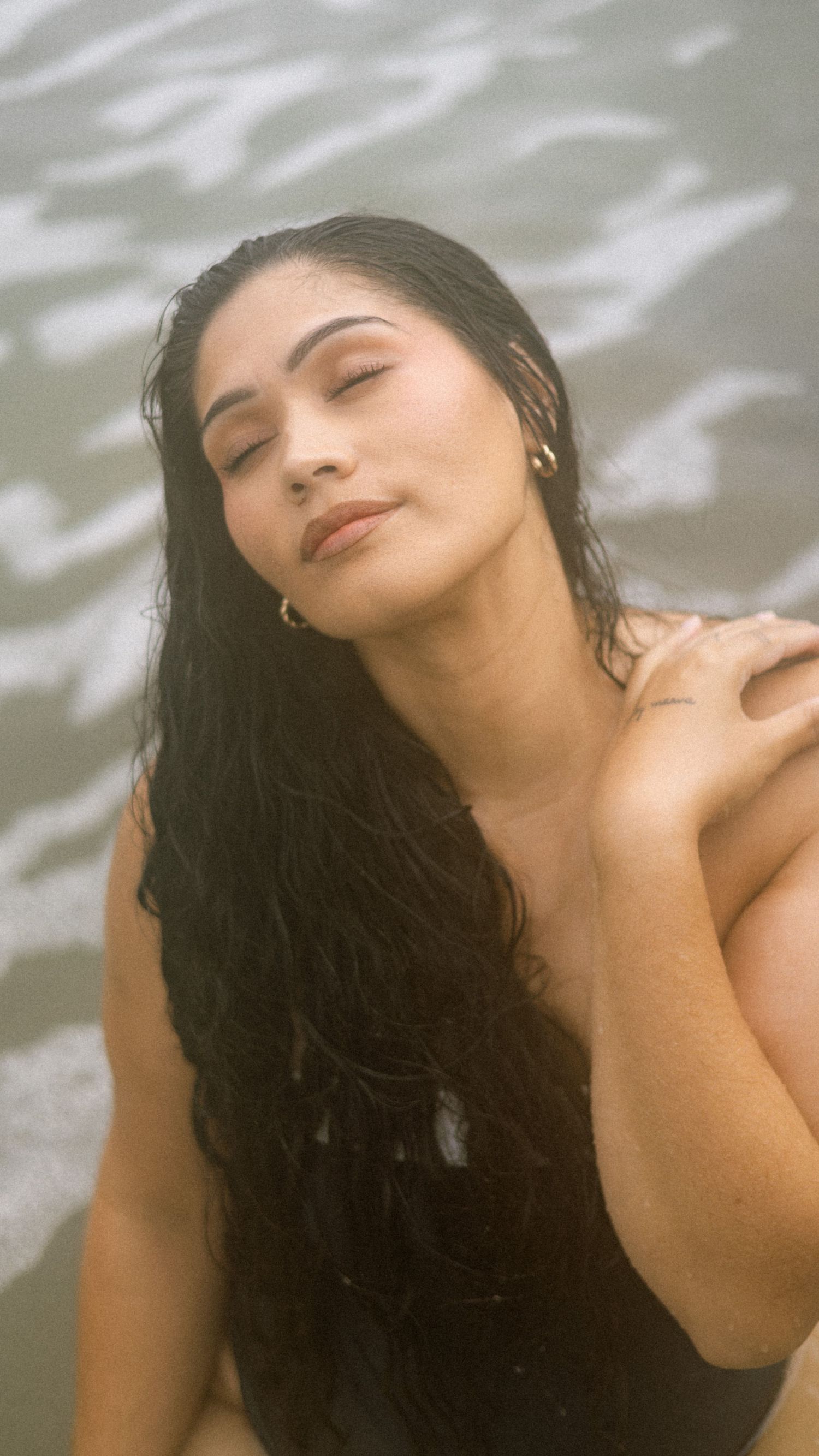 A series of artistic black and white portraits showing a person with long dark hair in water creating a dreamy effect.