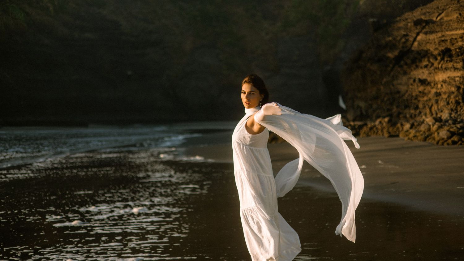 Ethereal dance movements captured against dramatic coastal cliffs and crashing waves.
