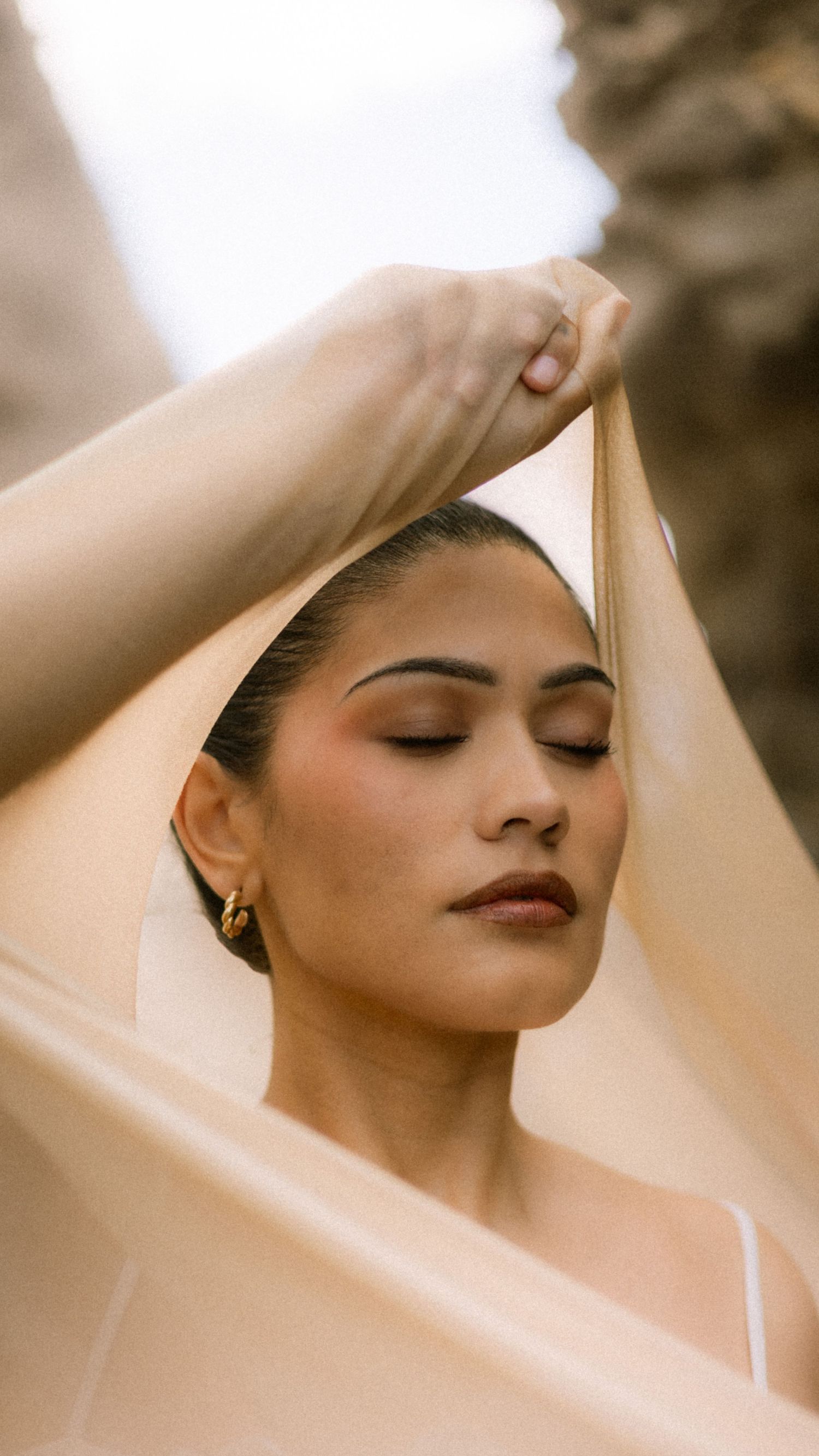 A series of sepia-toned artistic portraits showing graceful poses with arms raised and eyes closed.
