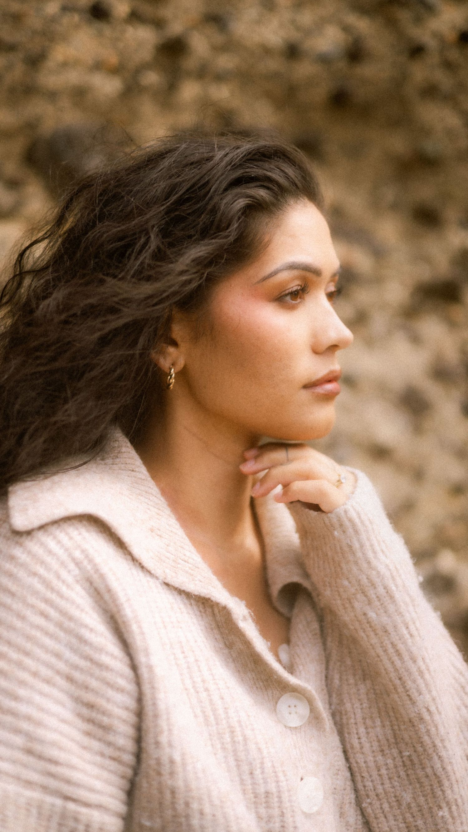 A person in a beige knit sweater gazes thoughtfully into the distance in a series of profile shots.