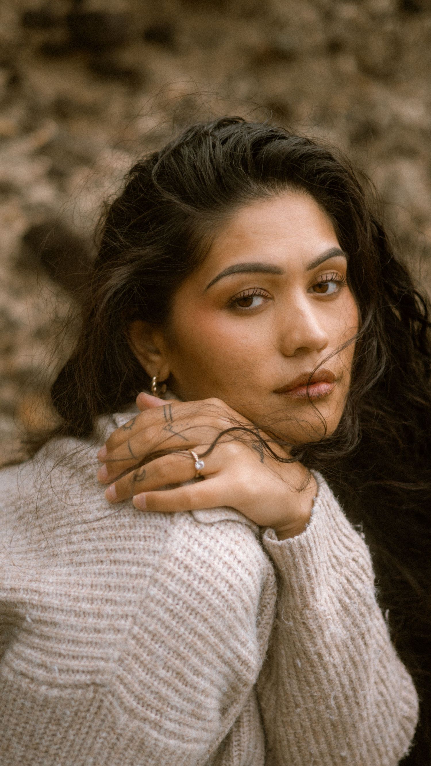 A series of moody portrait shots showing someone in a cozy white sweater against a dark background.