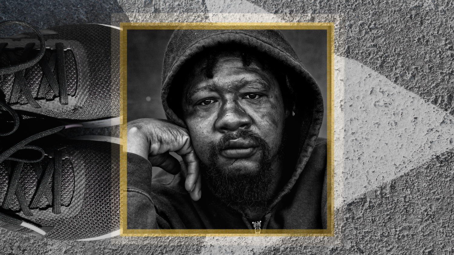 Black and white portrait of a homeless man photograph with a yellow square frame showing a person wearing a hooded garment.