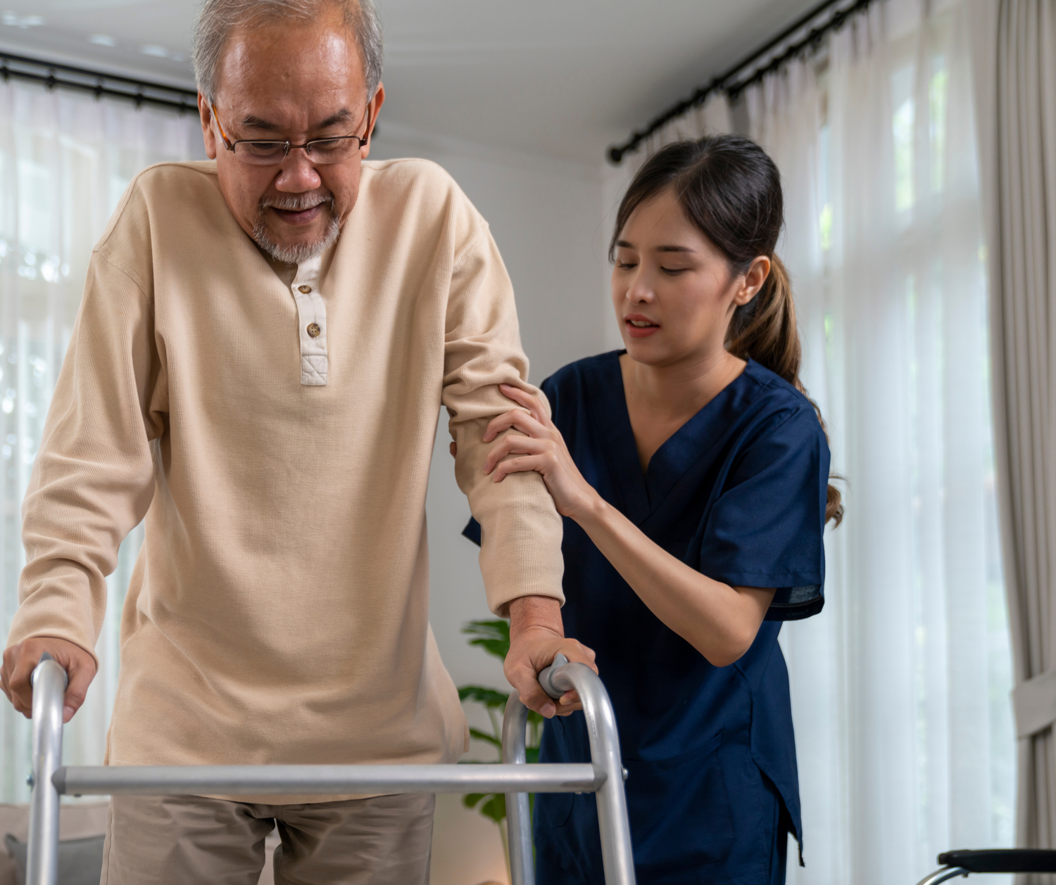 Healthcare worker assists elderly patient with physical therapy exercises in a bright medical facility.