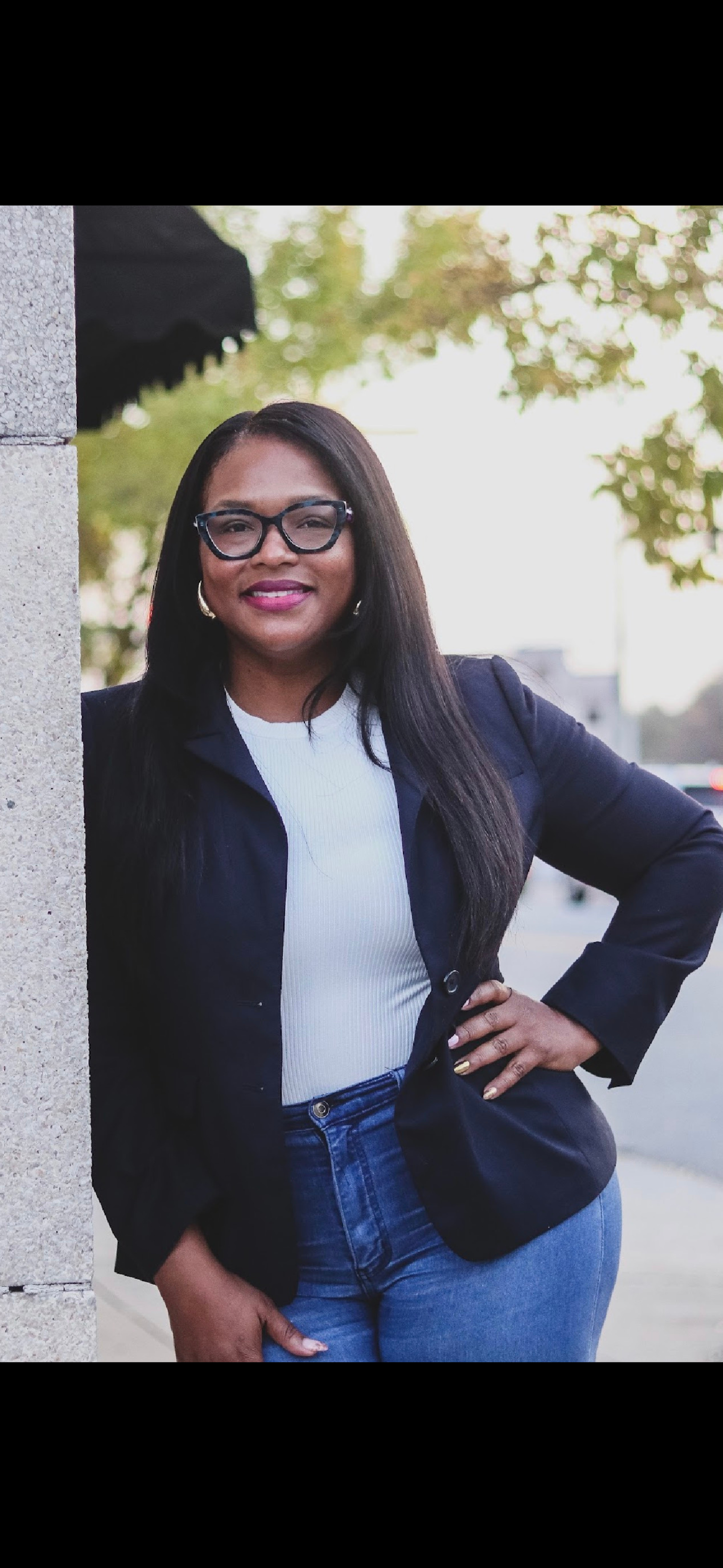 Photo of Owner/Founder Mary Owens. She is wearing a navy blazer, white top, and glasses while posing against a light background.