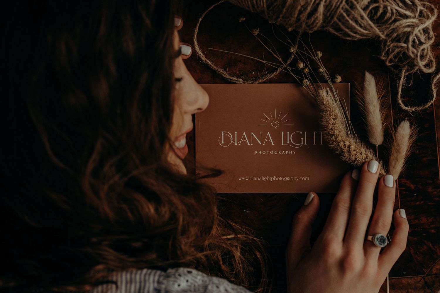 Rustic brown leather photography packaging with string and prints displayed on textured background.