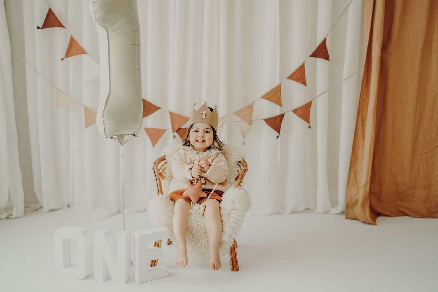 Candid family photo series showing joyful moments against a white curtain backdrop with orange banner decor.