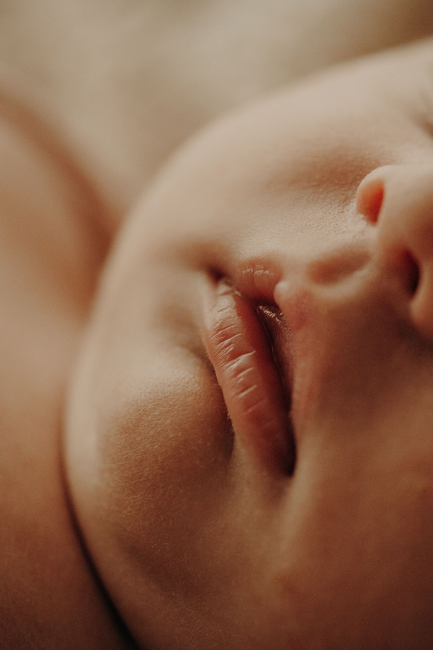 Close-up macro shots of a baby's delicate facial features in warm tones.