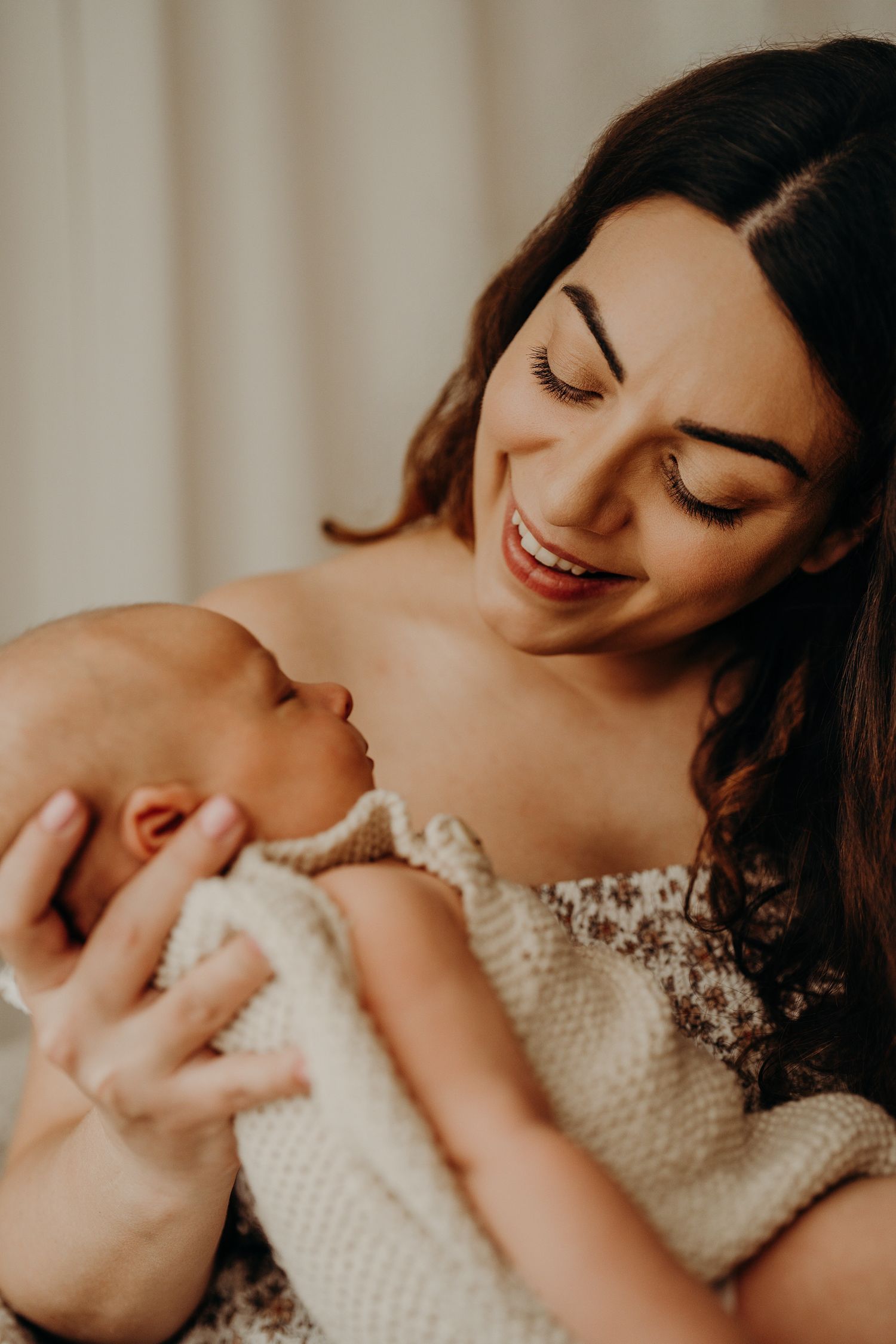 Tender moment captured between parent and baby in soft natural light.