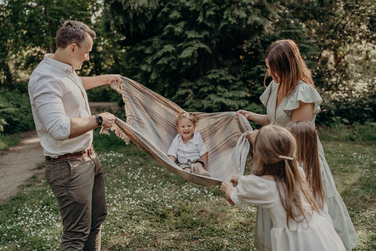 Family members playing and interacting joyfully in a lush garden setting.