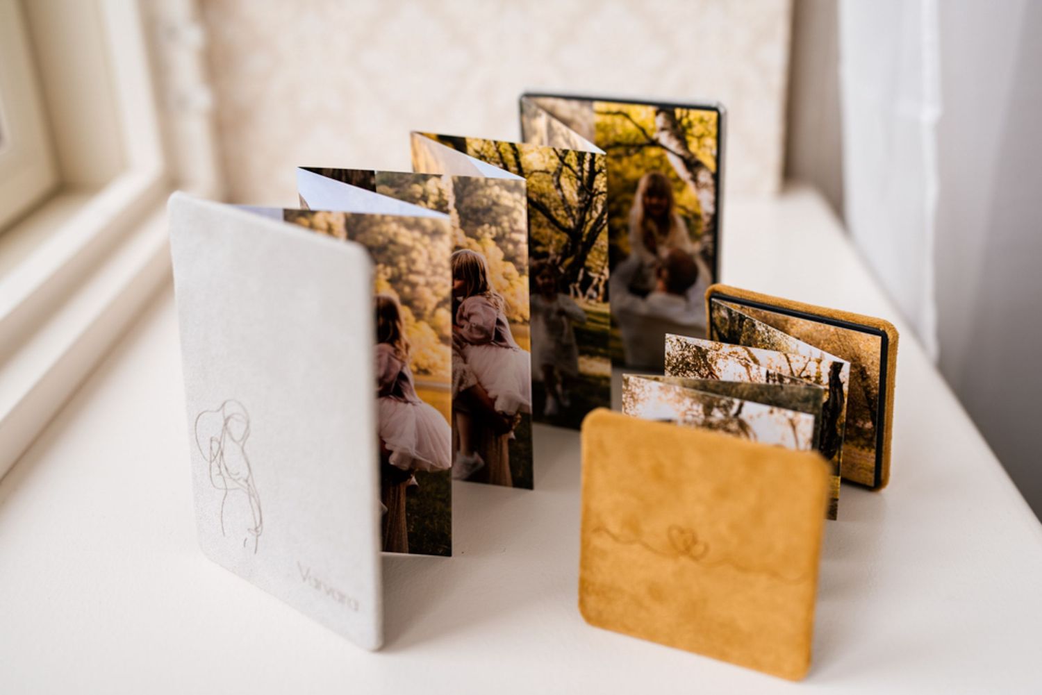 Handcrafted photo album with artistic fold-out pages and natural elements on white background.