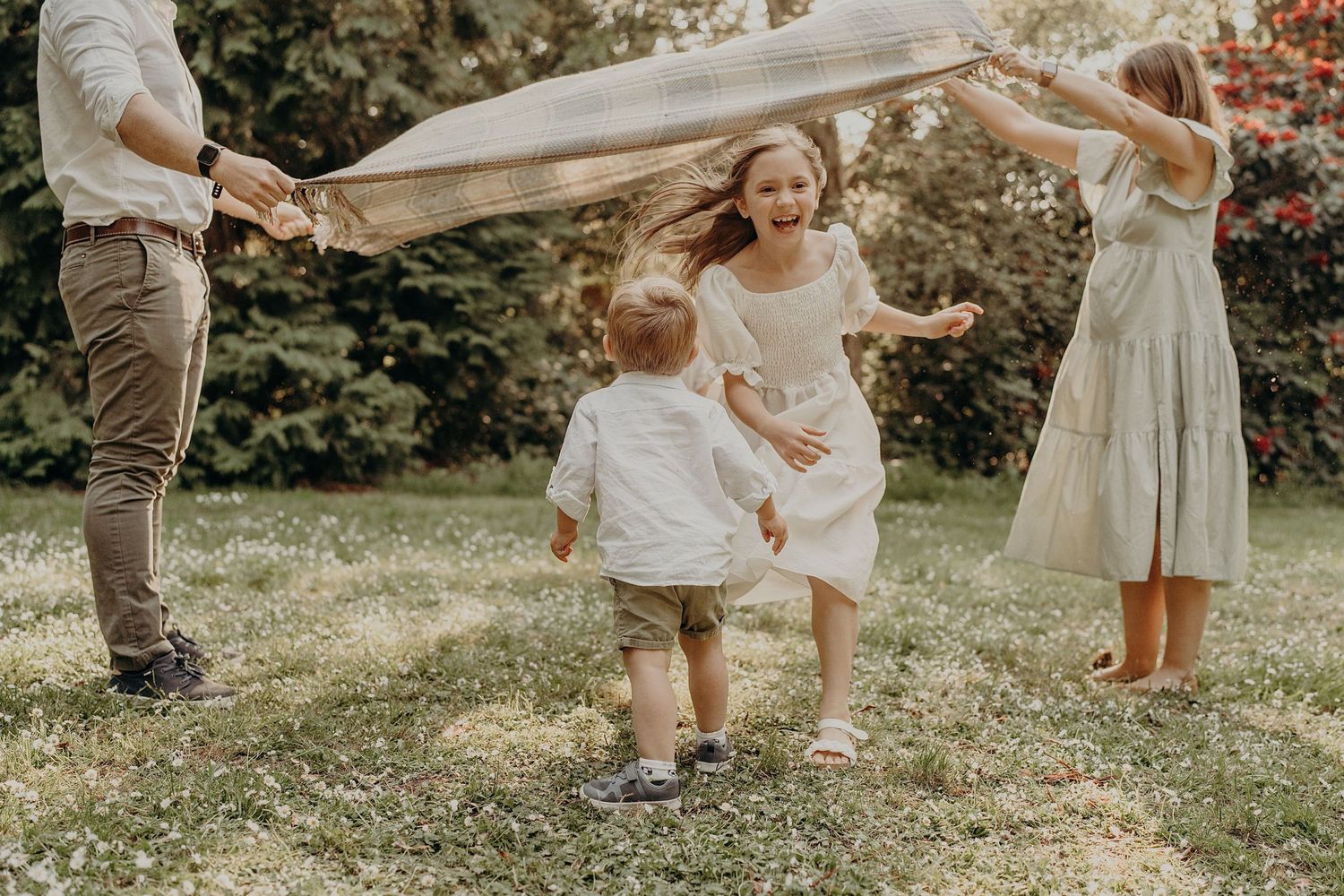 Candid family interactions captured in natural outdoor setting with golden light.