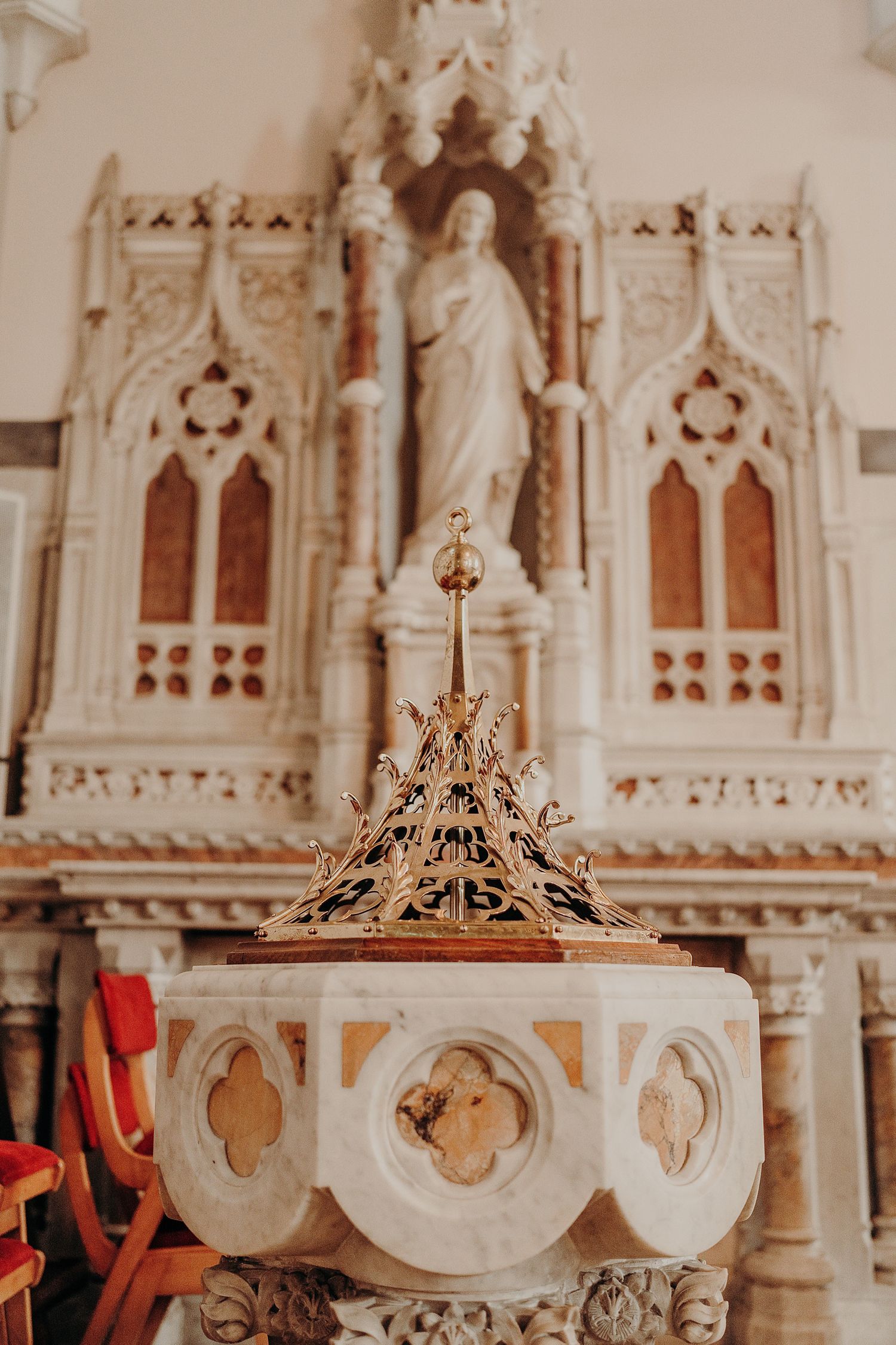Ornate golden crowns displayed on white decorative church altar with Gothic architectural details.