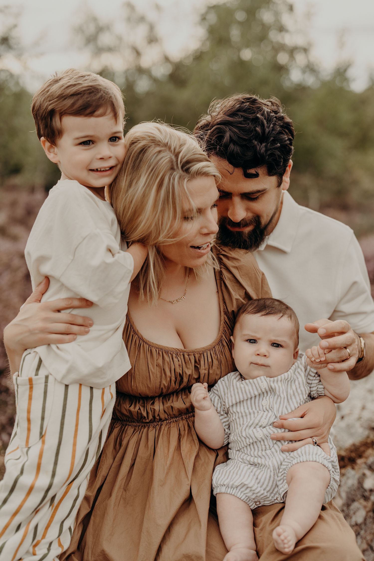 Candid family portrait session with natural expressions and warm earth-toned clothing.