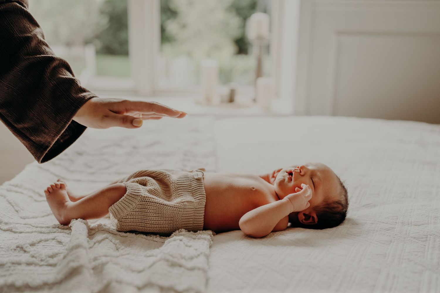Artistic lifestyle photography of newborn baby details in natural window light.
