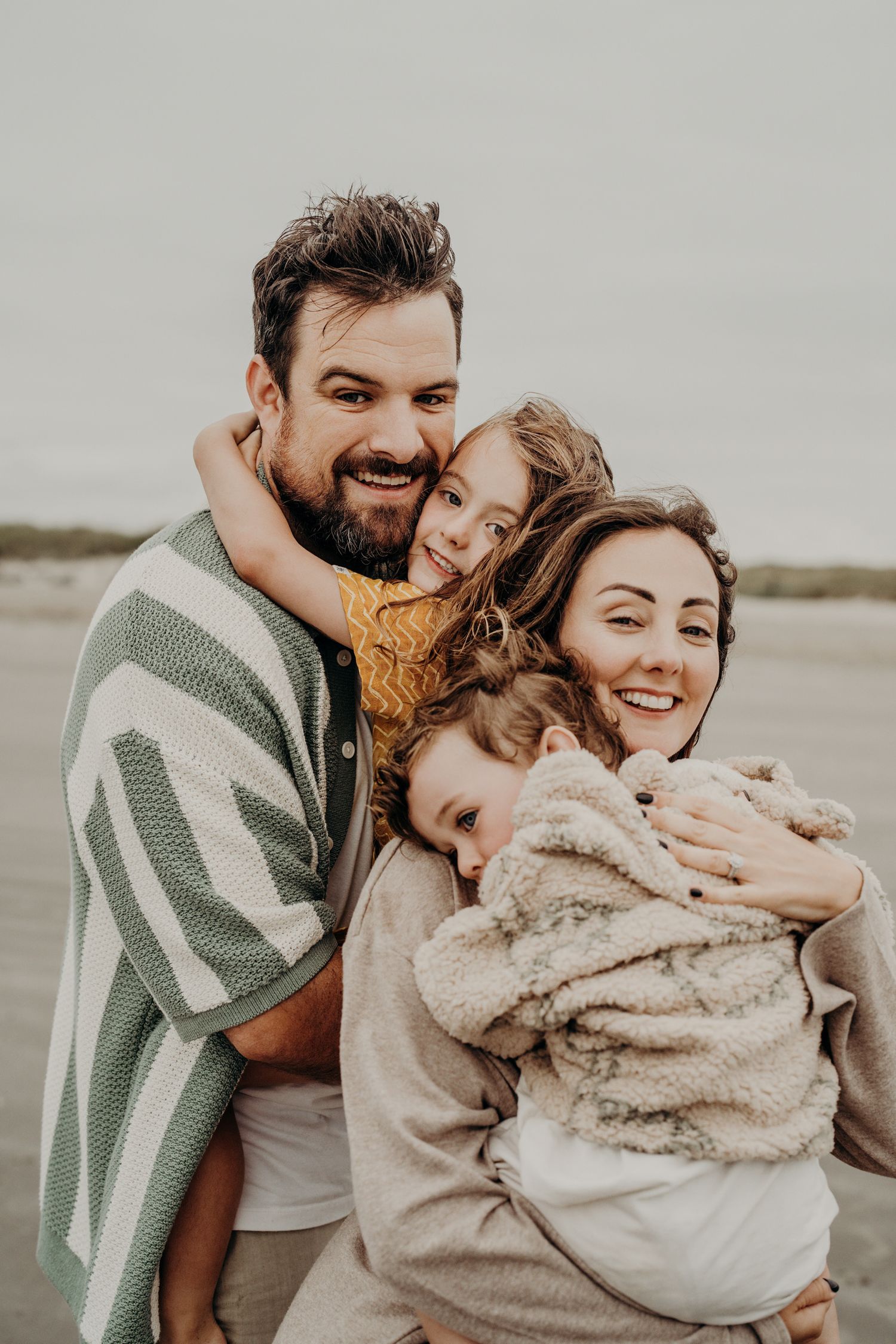 Intimate family embrace captured in a series of close-up shots on the beach.