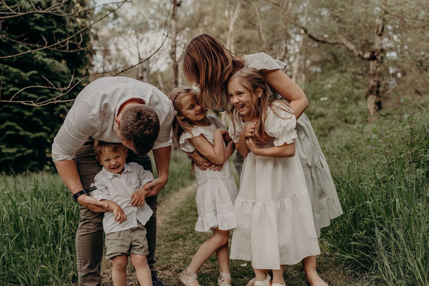 Family members share joyful moments together on a grassy field in spring.