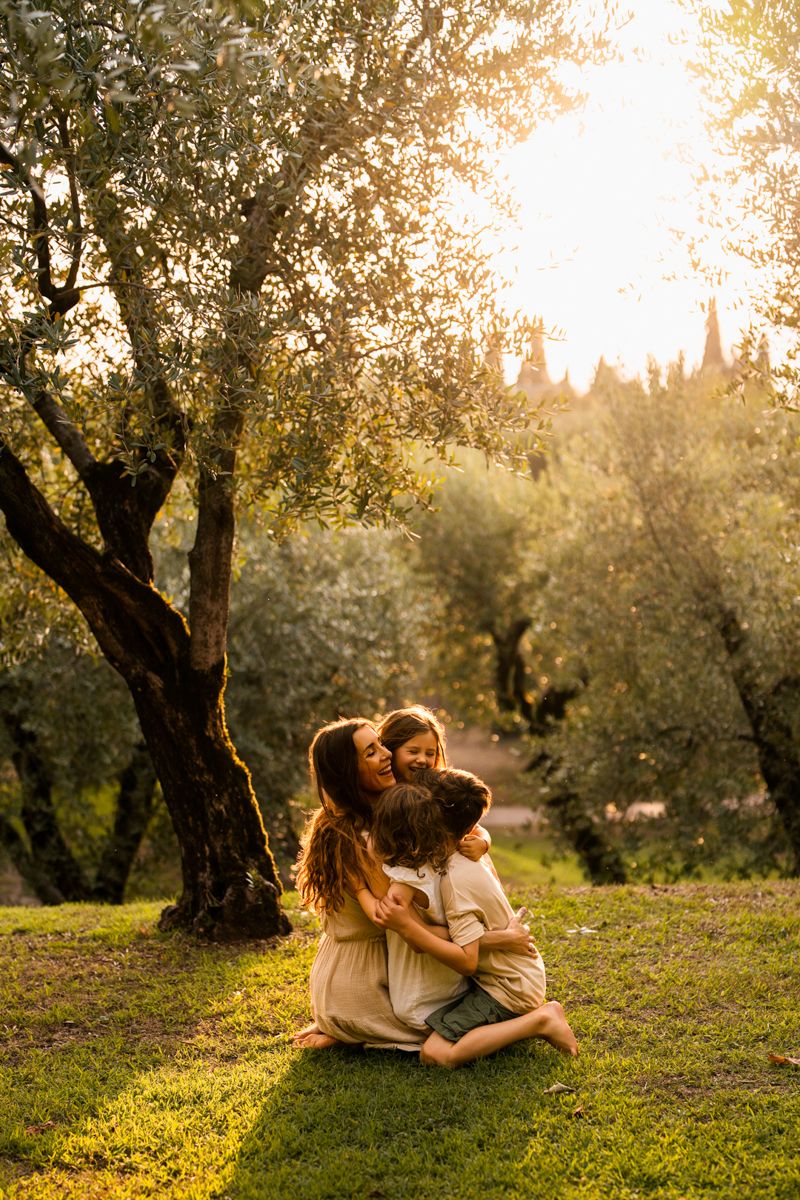 Romantic sunset photoshoot in an olive grove with warm golden lighting.