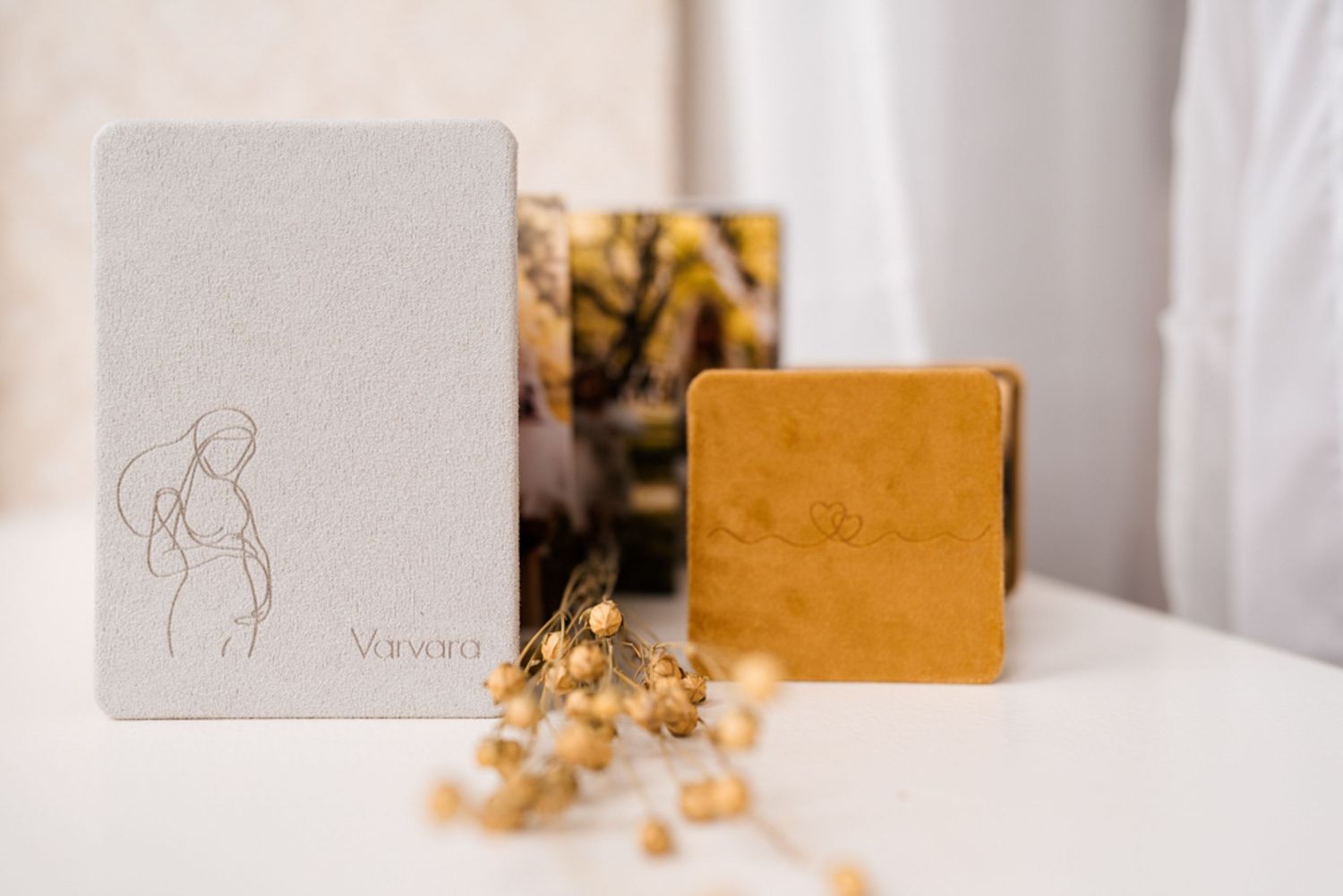 Minimalist photo album with pencil sketches and folded pages displayed on light surface.