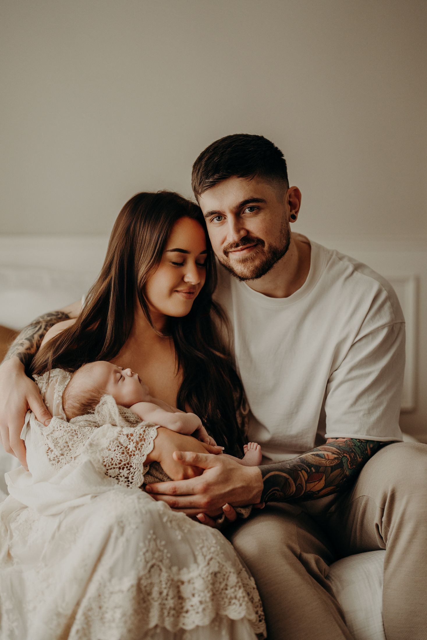 Happy parents cuddling their newborn during first days of parenting in natural lifestyle newborn session Dublin