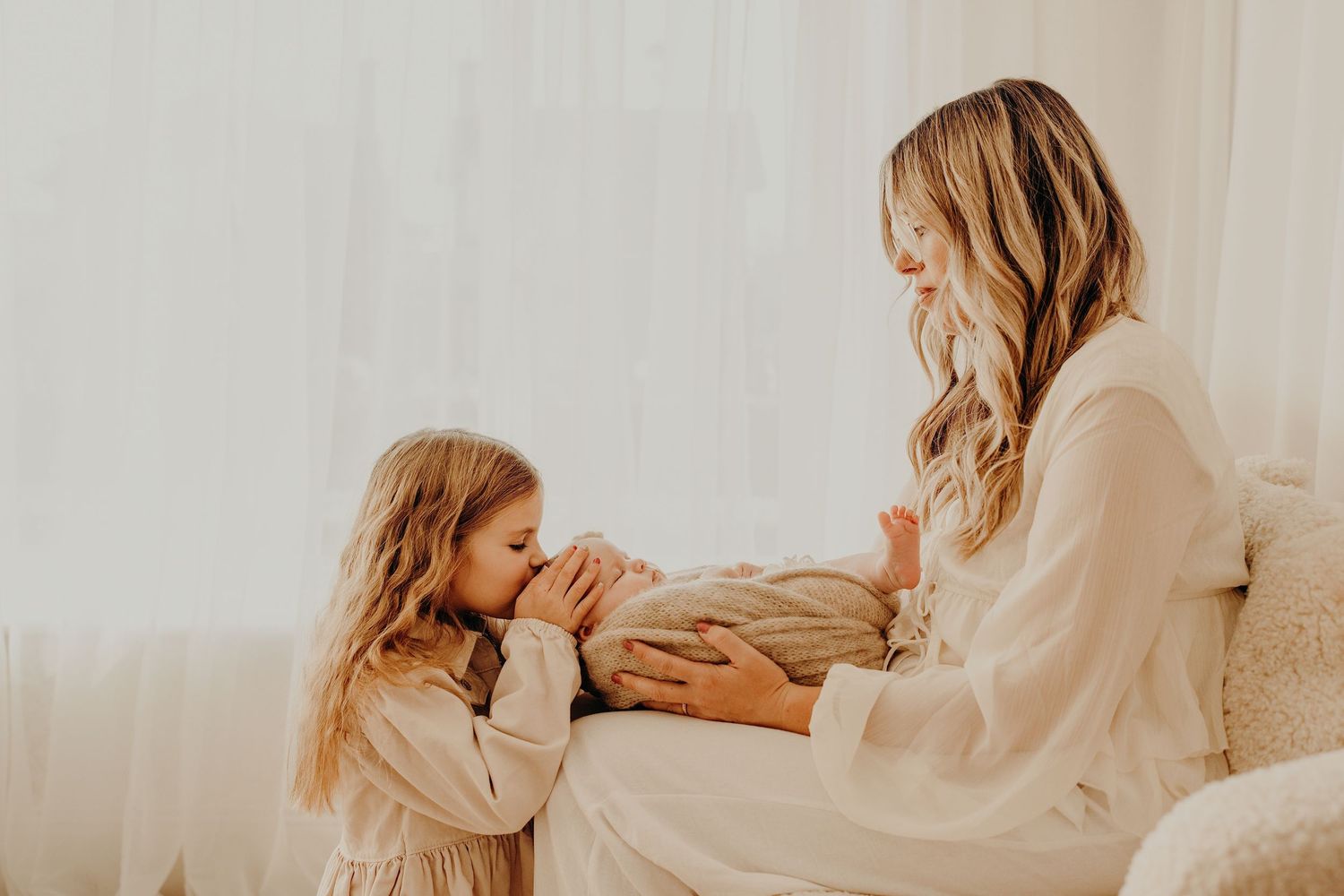 A tender family moment captured in warm tones with parents and children sharing loving interactions.