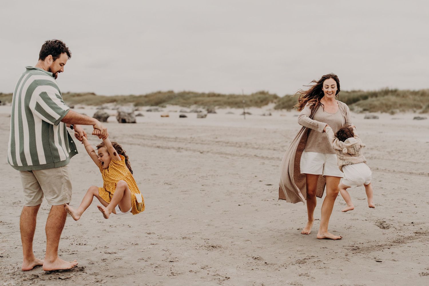 Playful family moments captured in sequence on an overcast beach day.