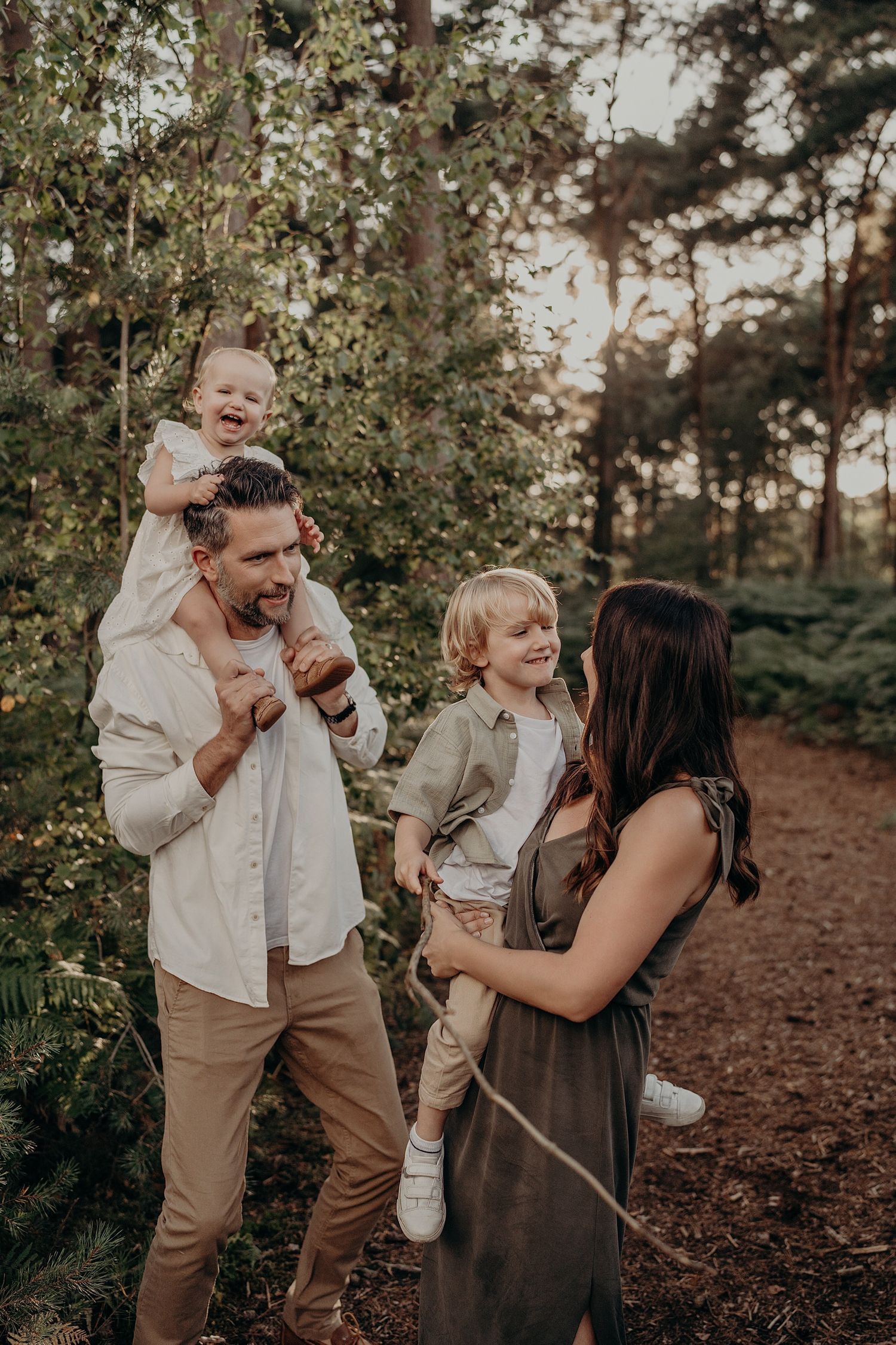 Candid family moments captured in a forest setting during golden hour with natural expressions.