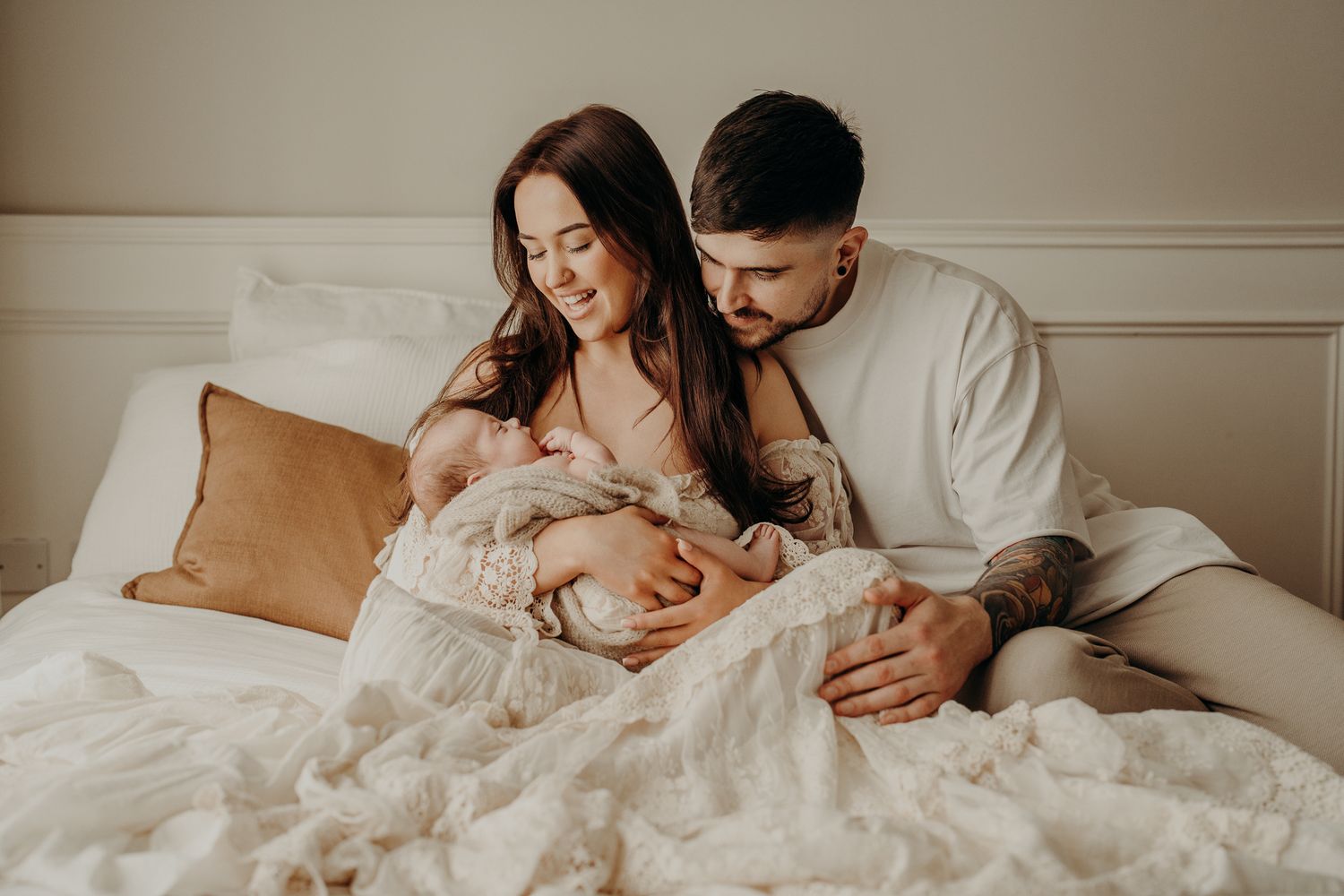 A loving couple shares tender moments with their newborn baby, natural studion newborn session Dublin.